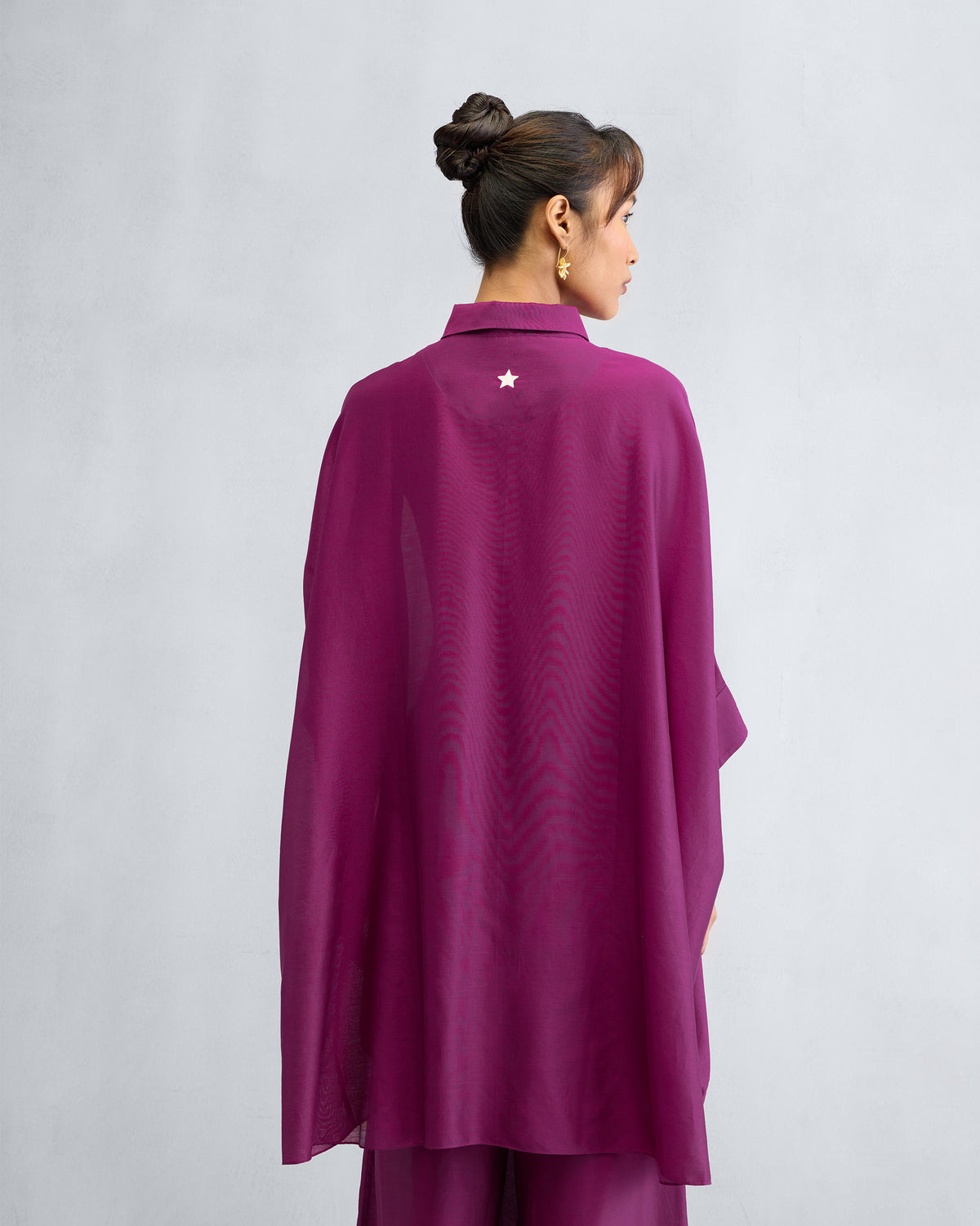 Back of a mulberry Hala tunic with a white embroidered star.