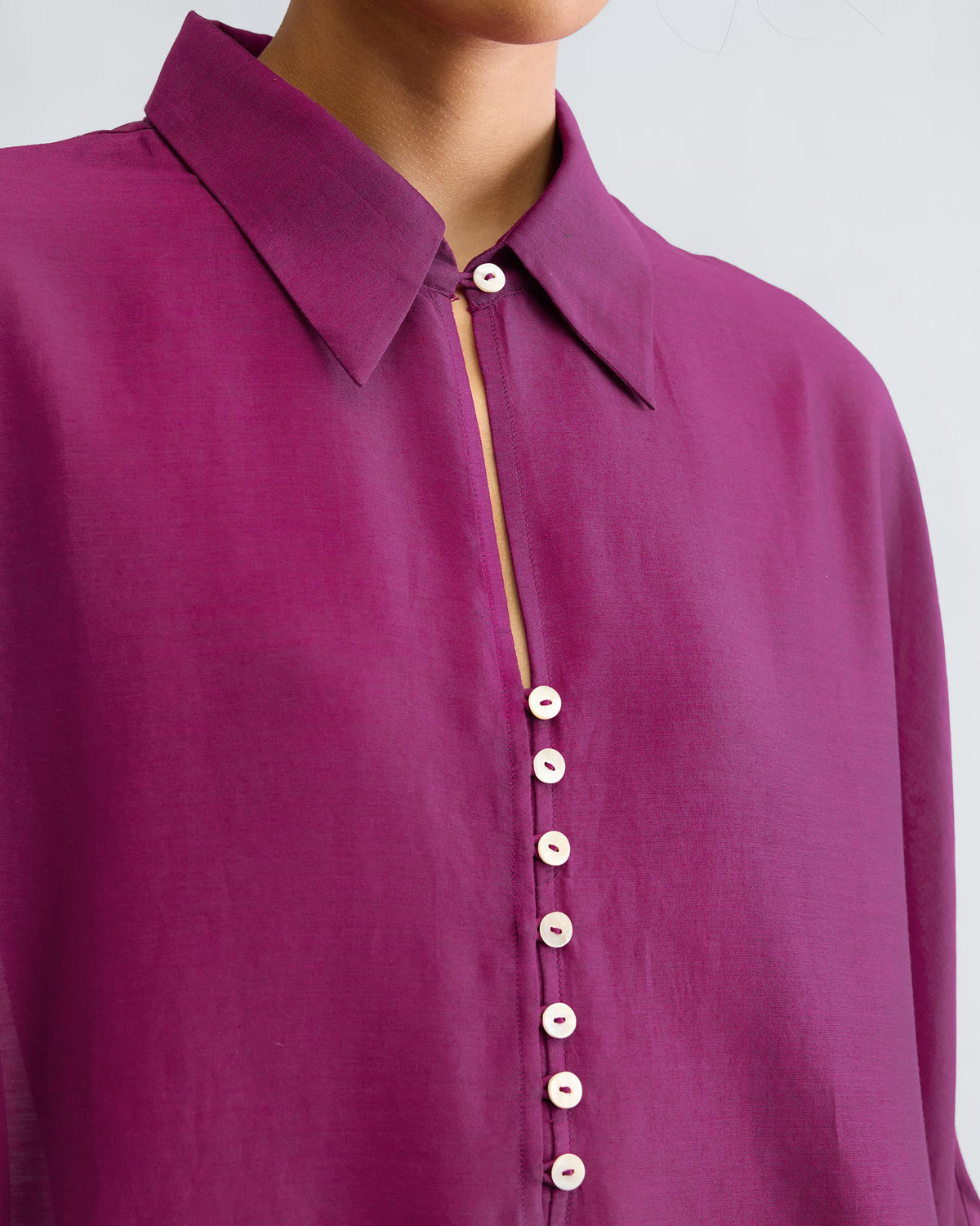 Close-up of a mulberry Hala tunic showing the collar and white buttons.