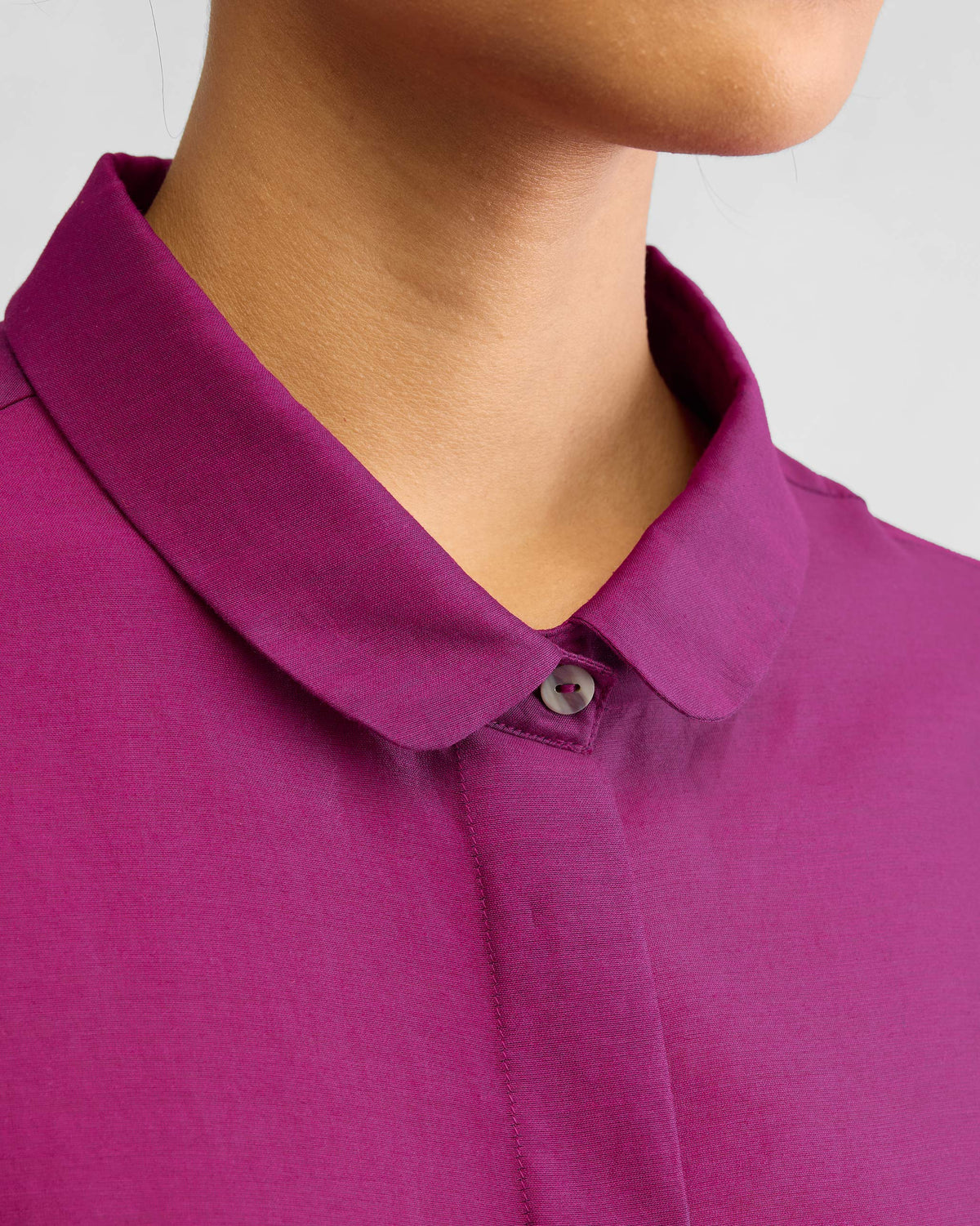 Close-up of the rounded collar and hidden placket on a mulberry boxy shirt.