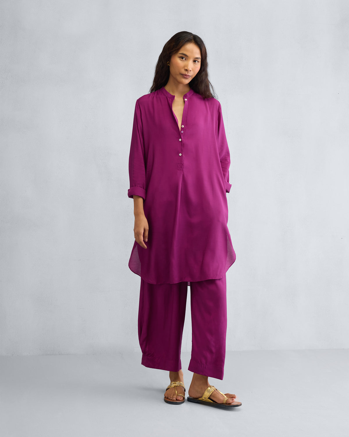 Person wearing a mulberry mid-length kurta set with a curved hem.