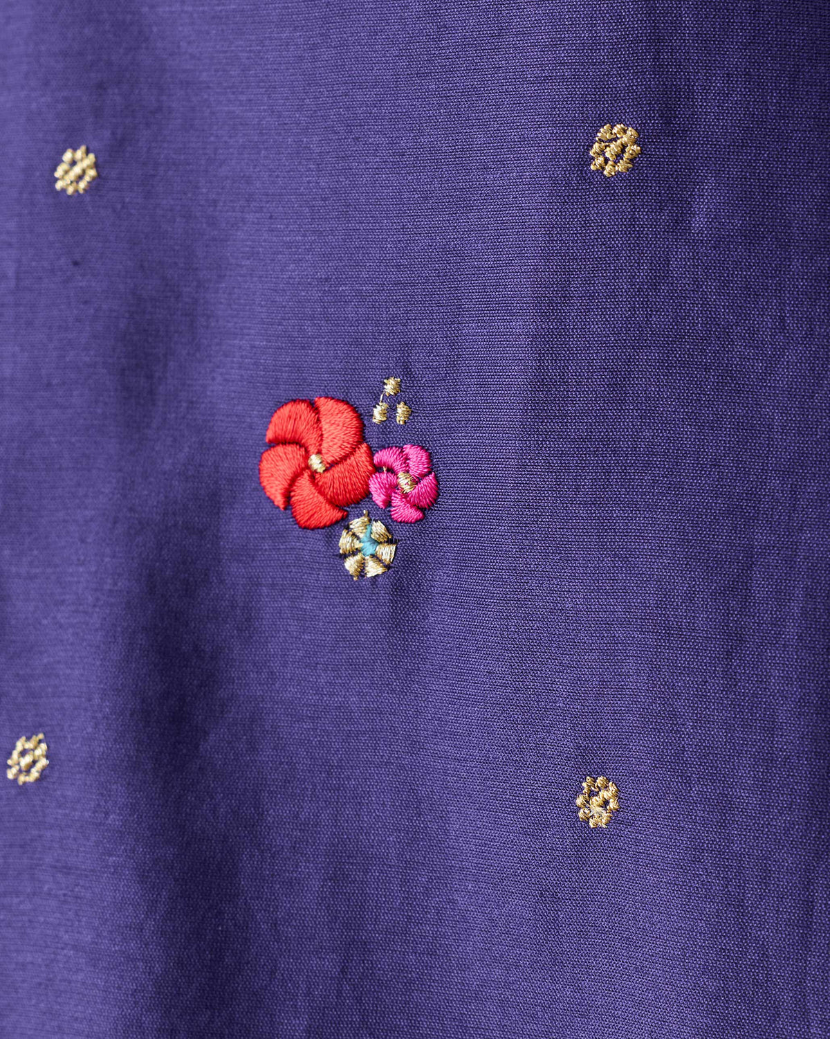 Close-up of red and pink embroidered flowers on a purple Nebula Kurta.
