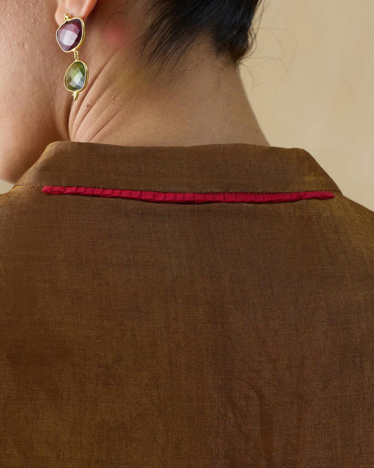 Close-up of the Tango kaftan's back collar showing red piping.