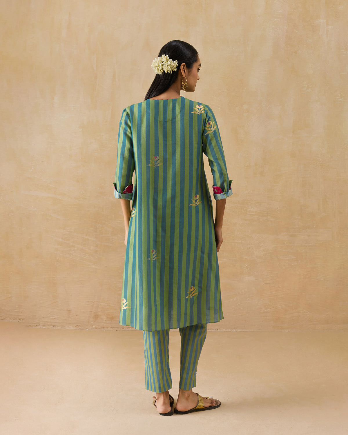 Back of a green and teal striped Front Pleated Kurta Set with gold motifs.