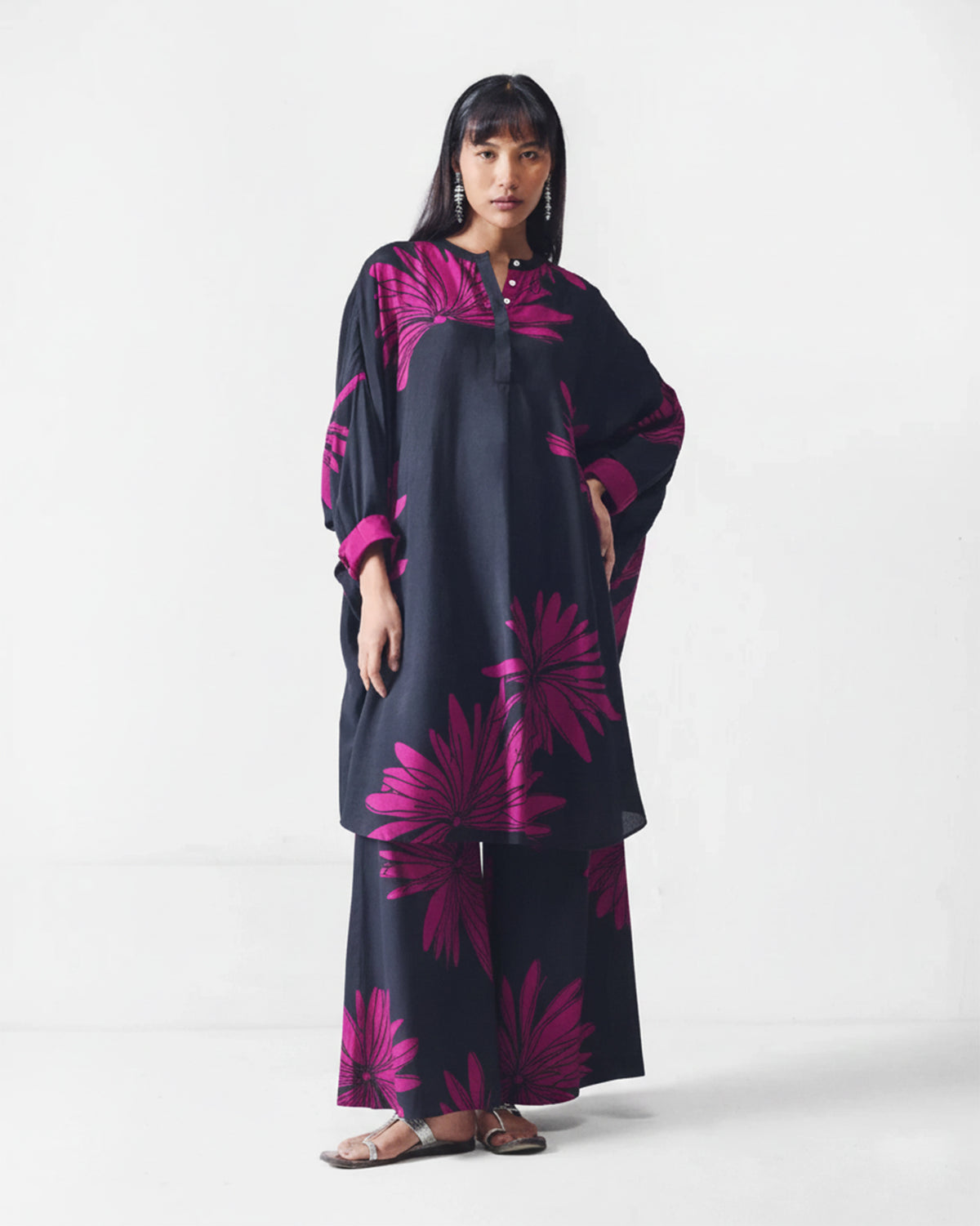 Person wearing a black Lazy Sunday tunic with a mulberry flower print.