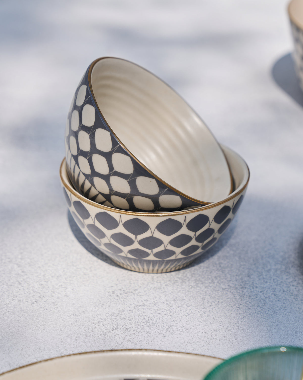 Nested Fez nut bowls showing charcoal petal pattern and cream interior.