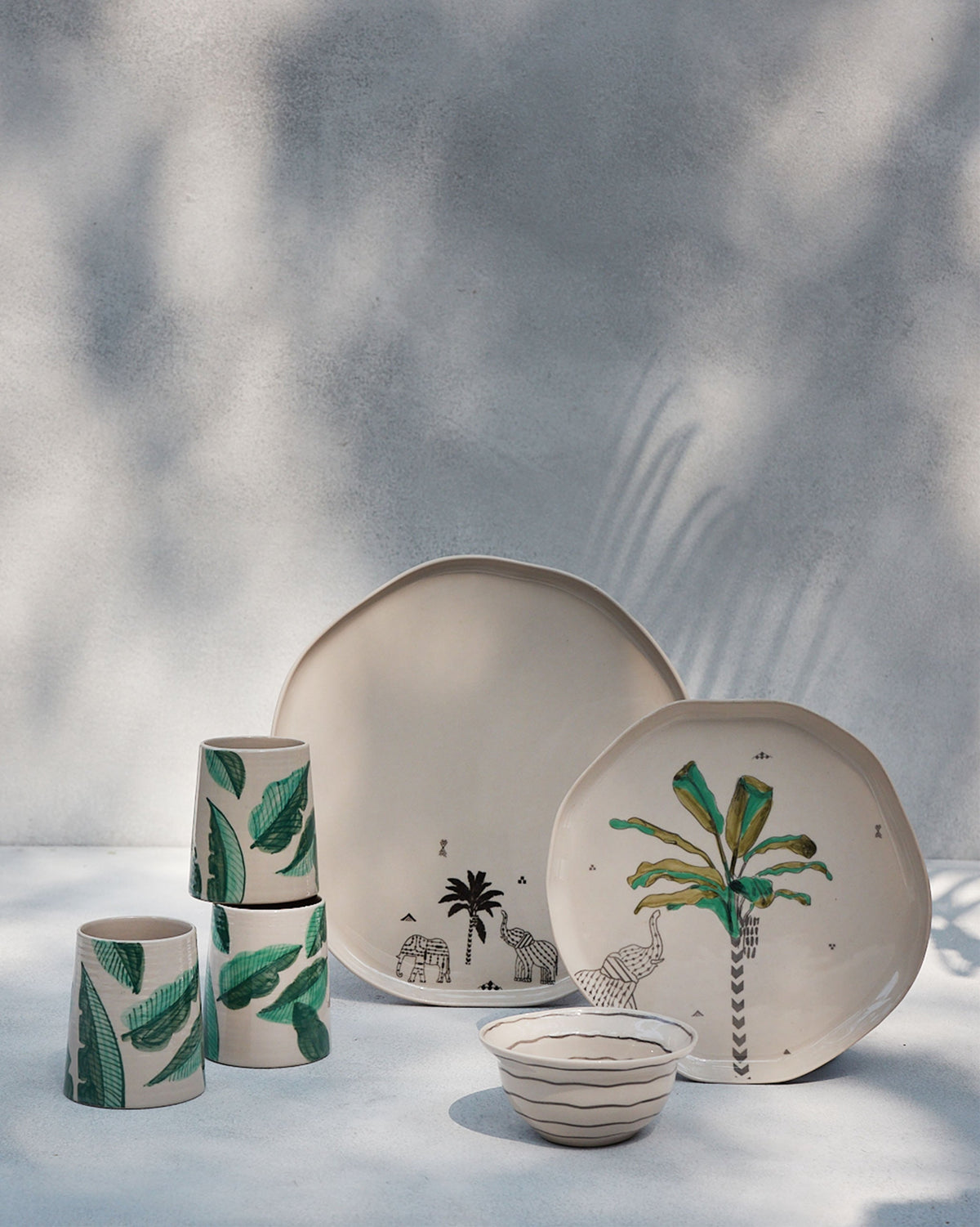 Ceylon thalis with elephant motifs styled beside banana-leaf tumblers.