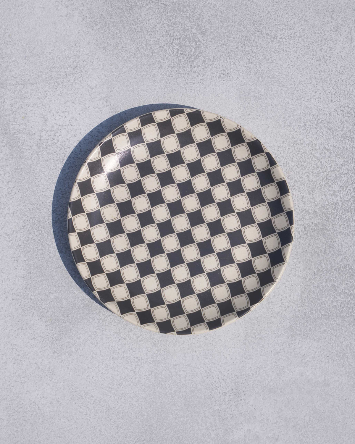 Round Fez quarter plate with charcoal and cream checker pattern.