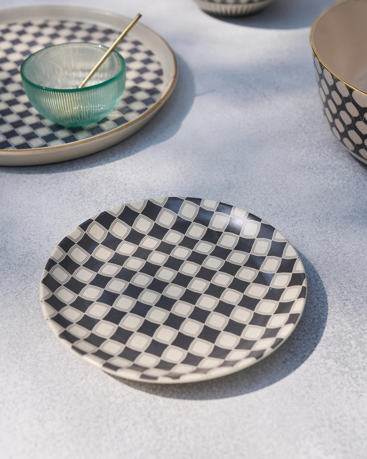 Fez quarter plate with charcoal checker pattern beside matching Fez serving pieces.