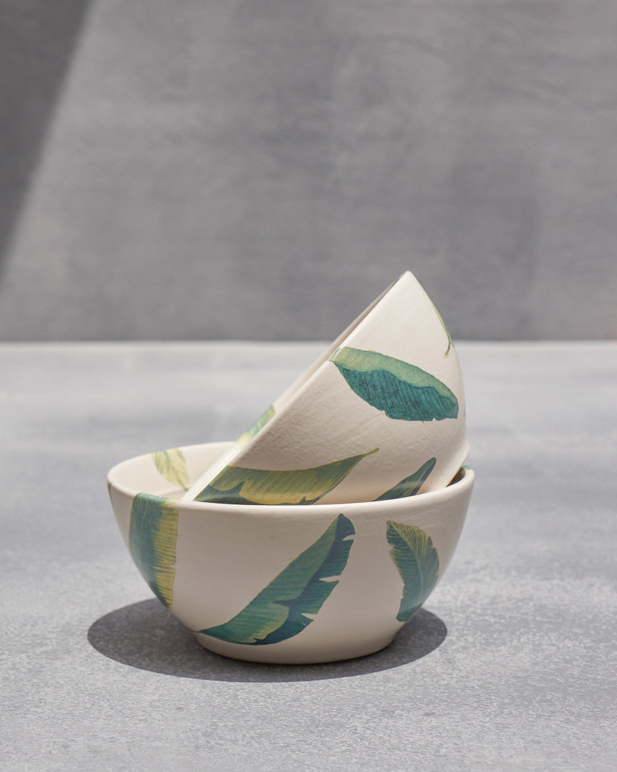 Nested Ceylon cereal bowls showing banana-leaf print inside and out.