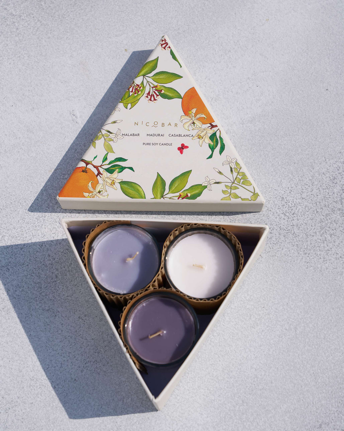 Open Trio Candle triangular gift box with three soy votives inside.