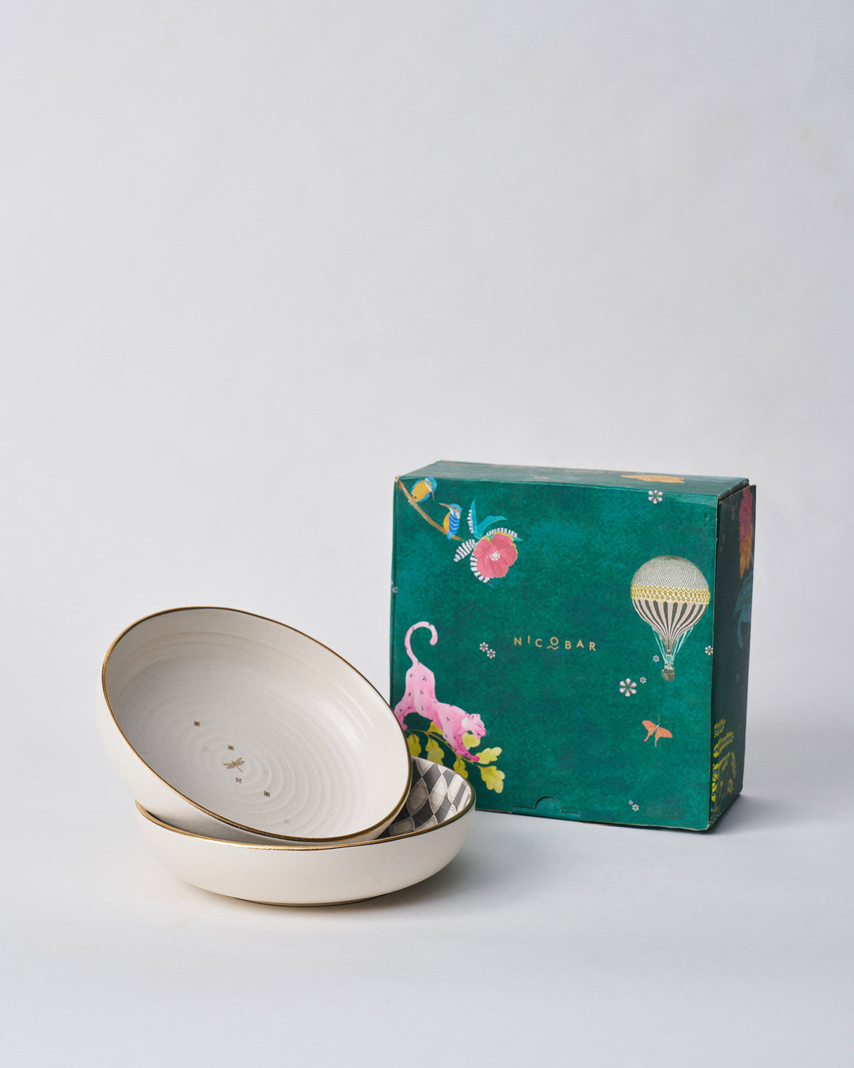 Fez Shallow Bowls stacked beside a teal Nicobar gift box.
