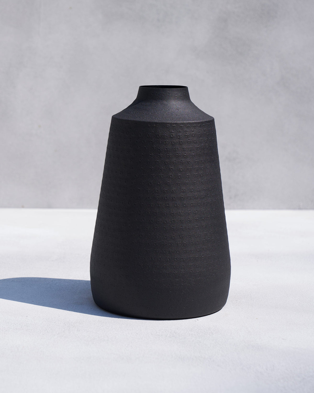 Tall Midnight vase in matte black with a tapered textured silhouette.