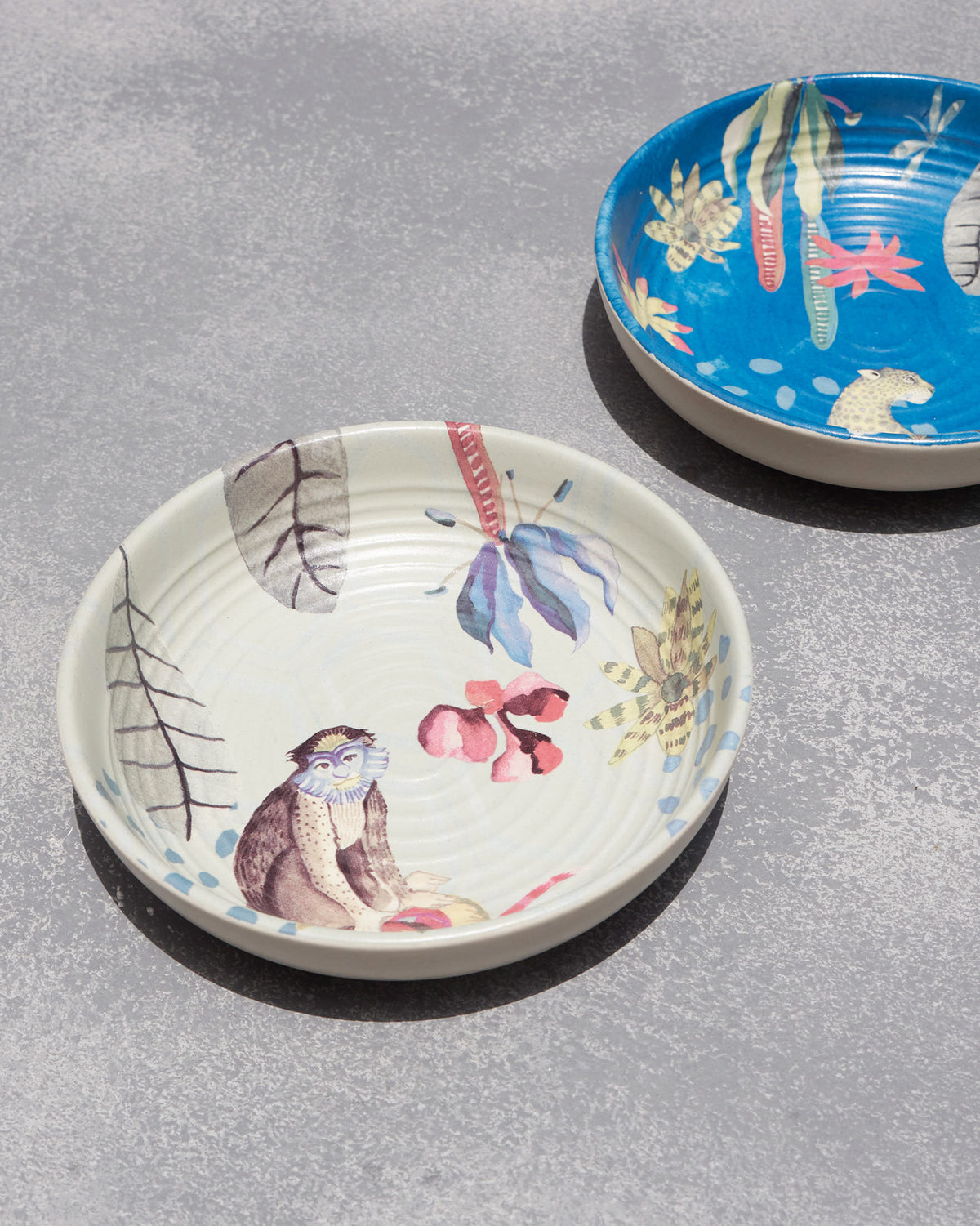 Pair of Mahi shallow bowls with monkey and leopard coastal motifs.
