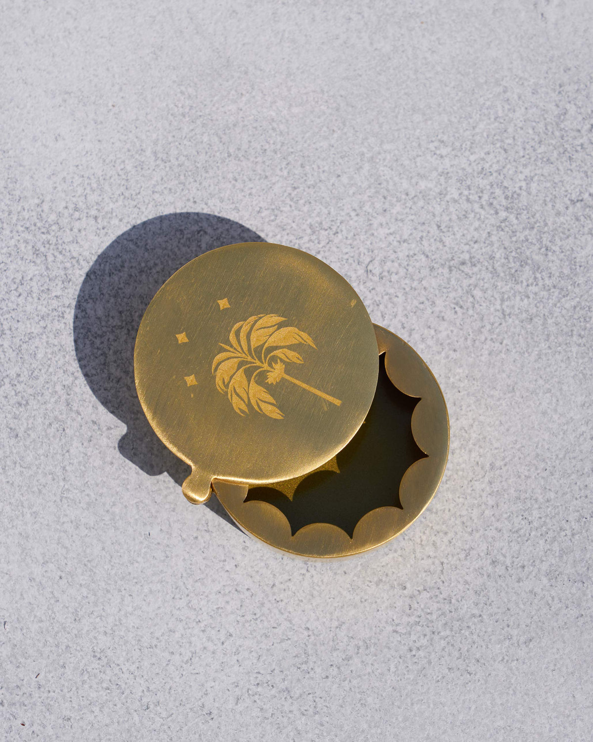 Open gold Waadi kesar box showing the scalloped inner rim.