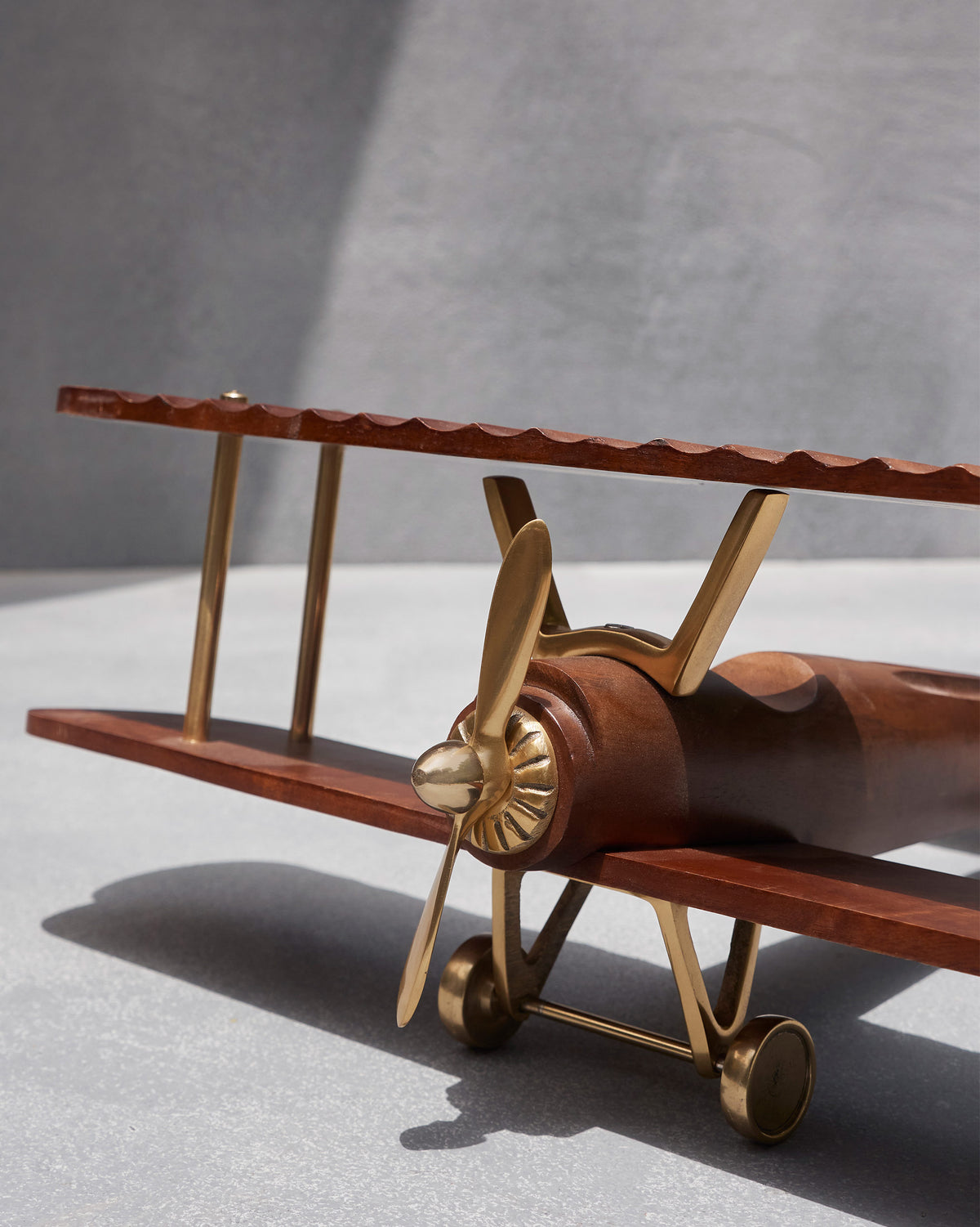 Close-up of a wood Beufort biplane with a brass propeller.