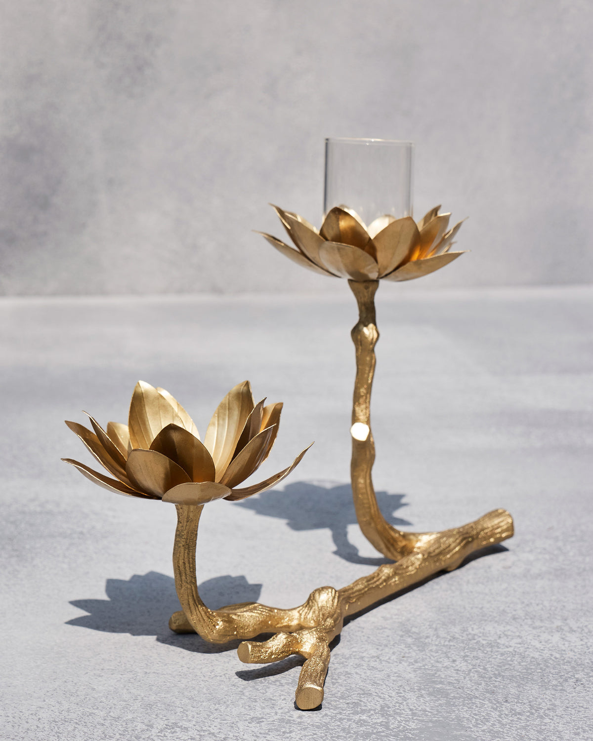Kamal tea light holder with twin gold lotuses on a textured branch base.