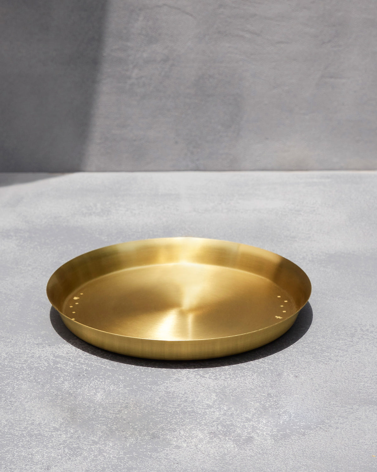Large brushed brass Madhu thali with small star motifs.