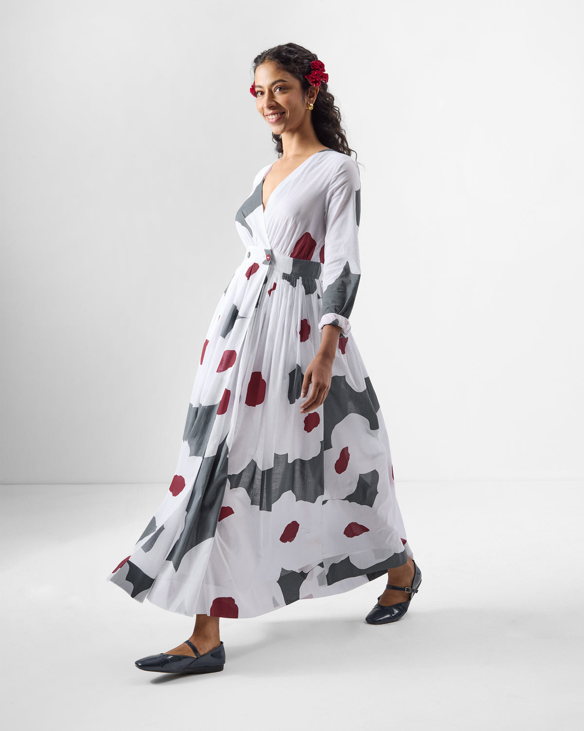 Person wearing a white Nico wrap dress with grey and maroon print.