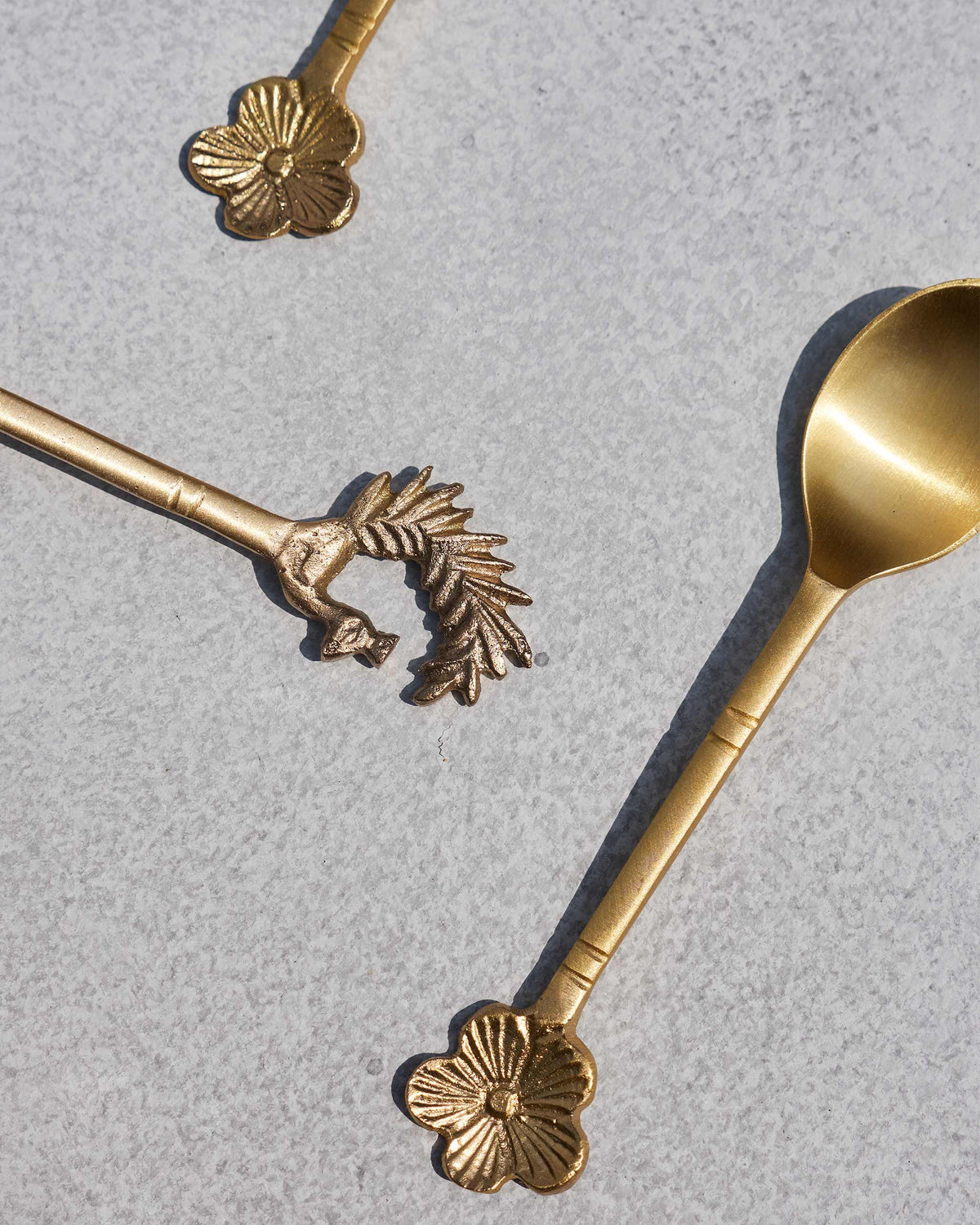 Detail of flower and peacock tips on brass Mizo coffee spoons.