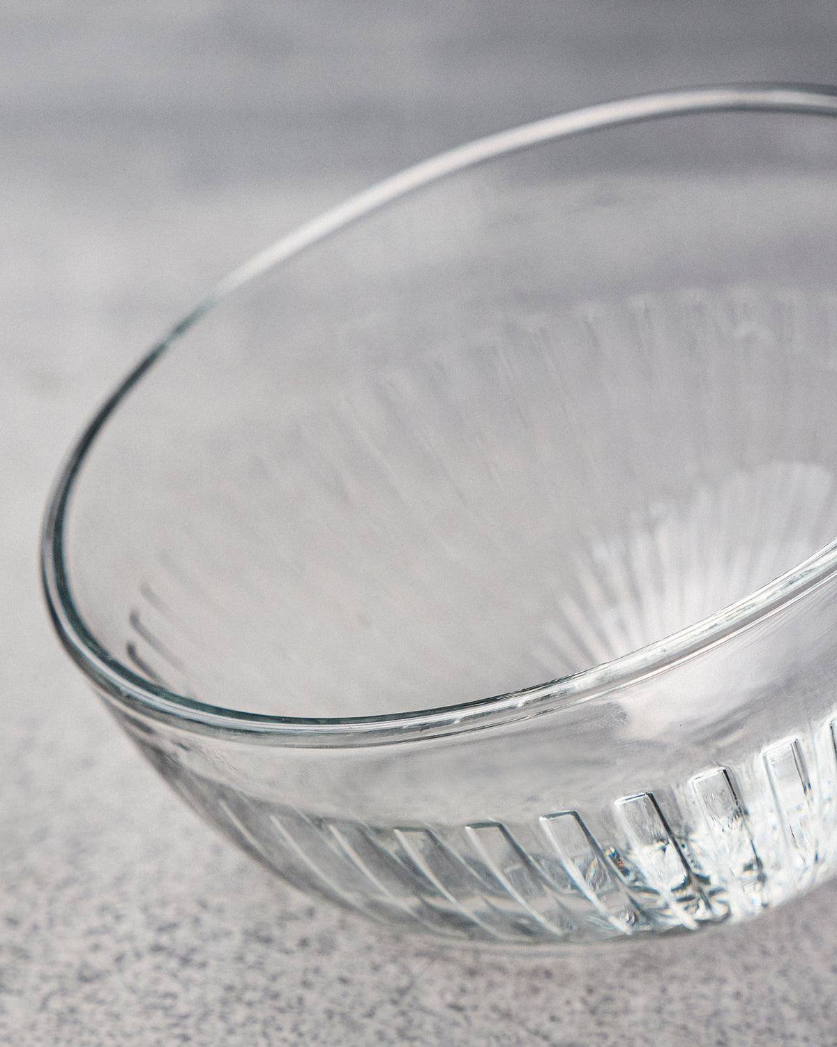 Close-up of a clear Mahi nut bowl showing vertical fluting near the base.