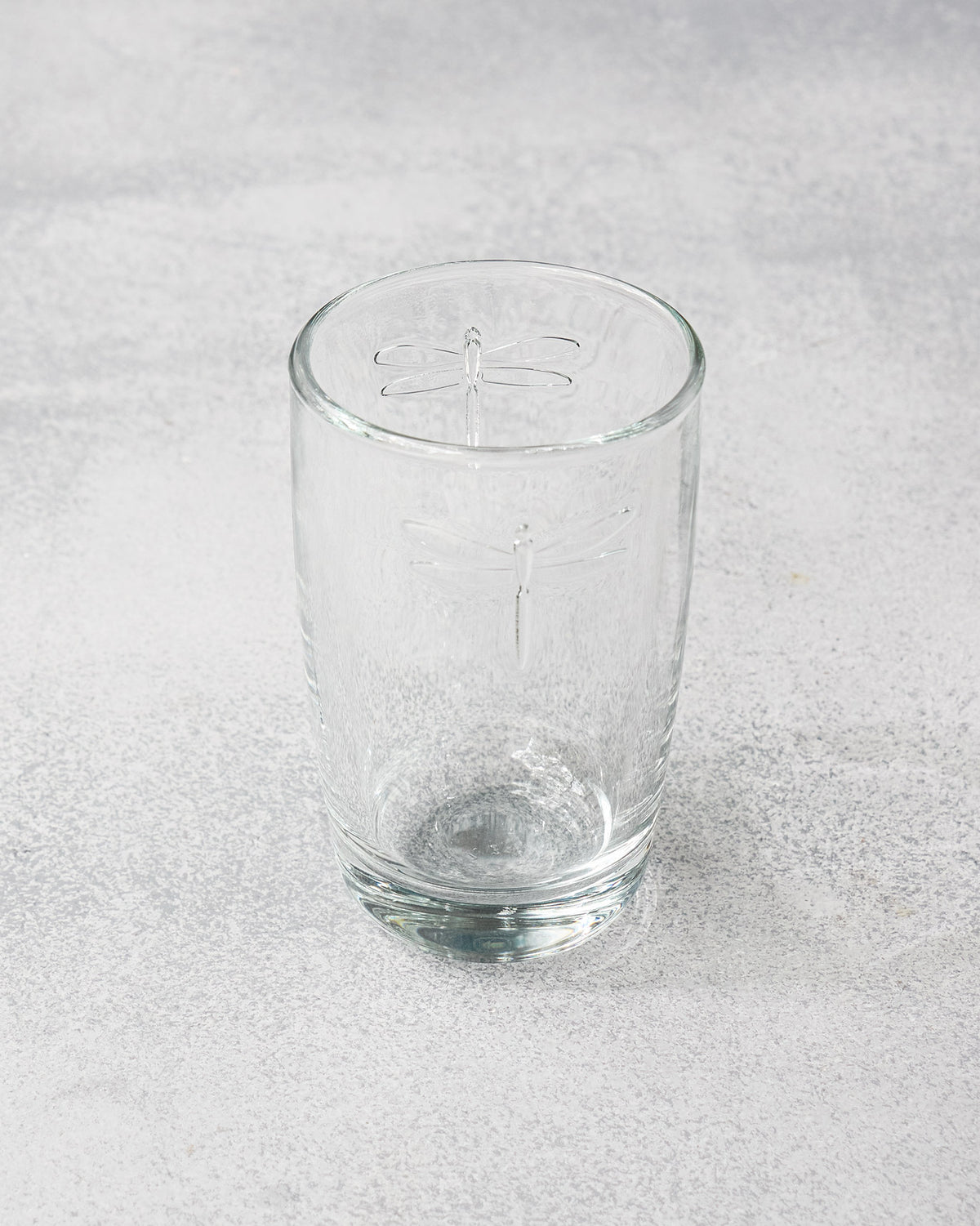 Clear Mahi long drink glass with an embossed dragonfly motif.