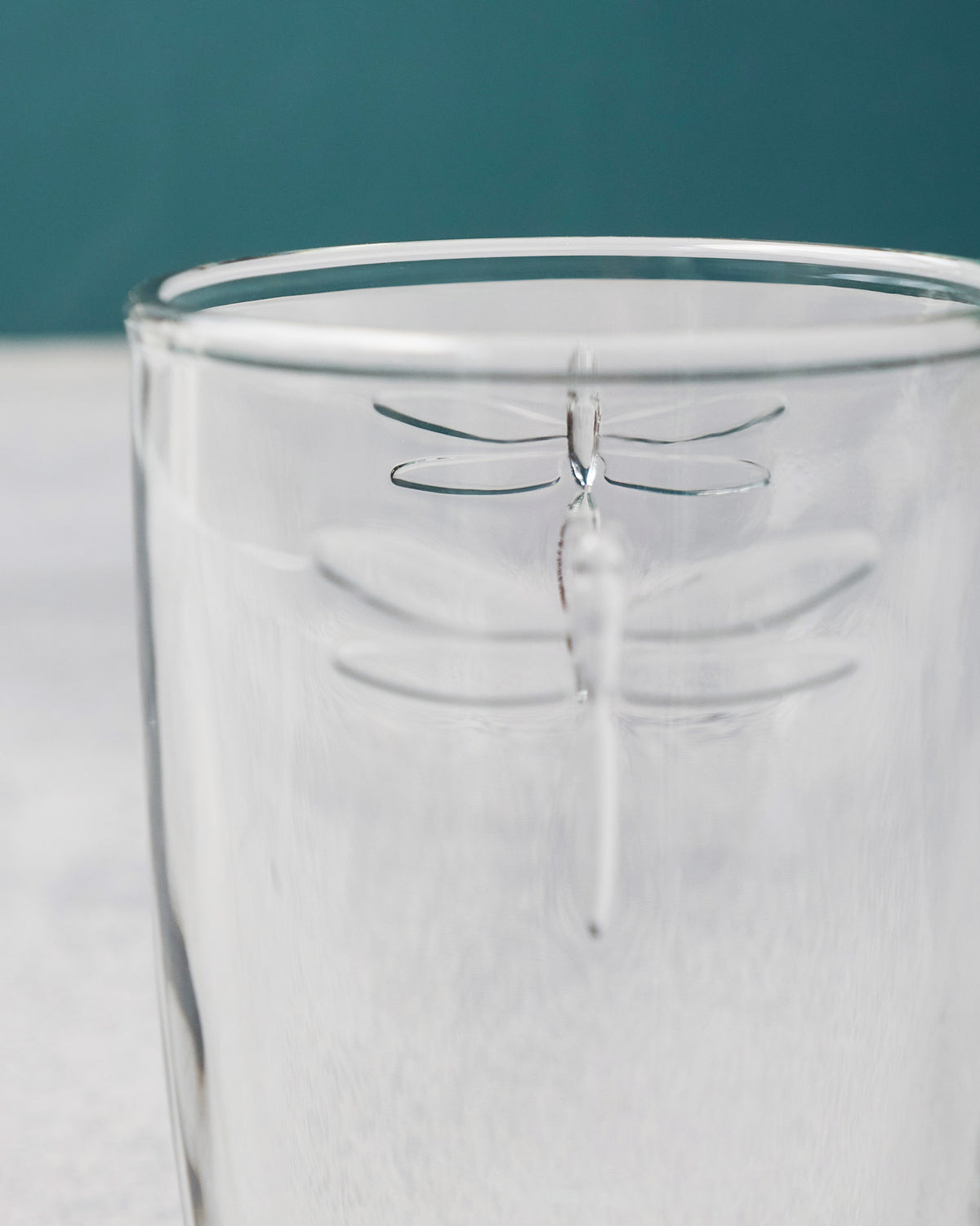 Close-up of the dragonfly motif on a clear Mahi long drink glass.