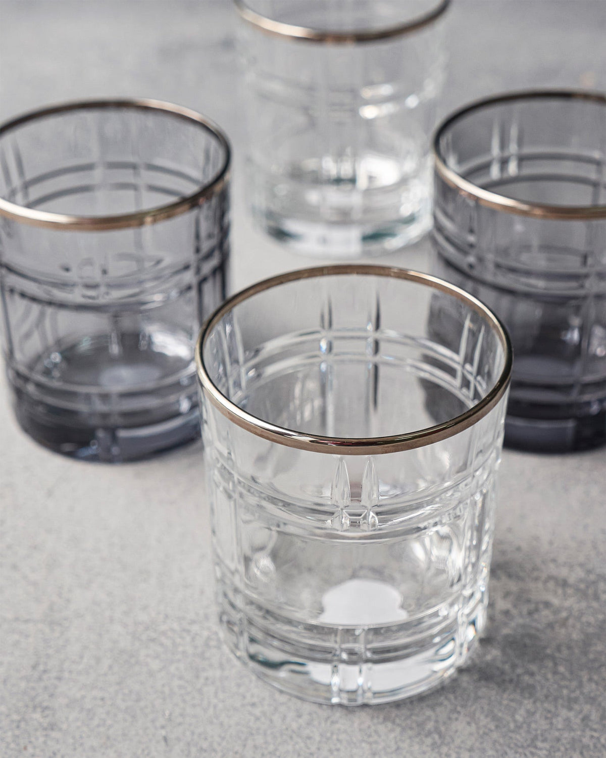 Overhead view of clear and smoky Celeste whiskey glasses with gold rims.