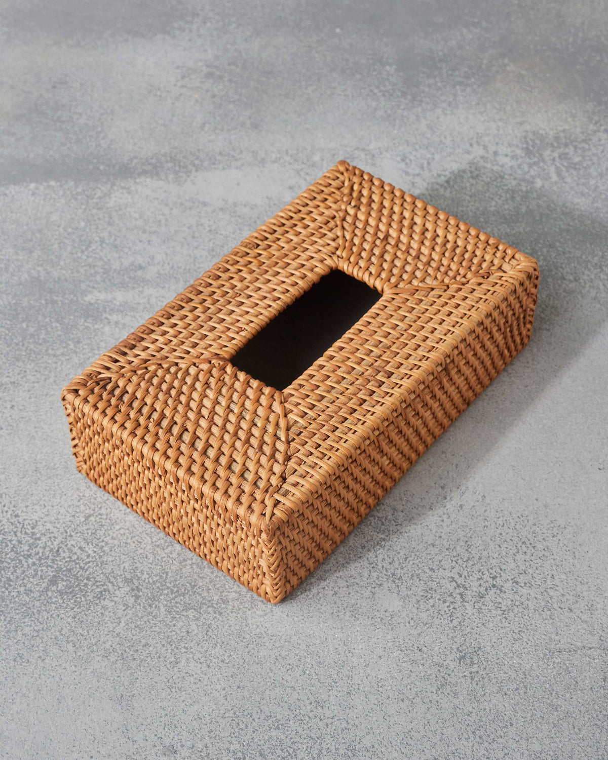 Overhead view of a rattan tissue cover with a central rectangular slot.