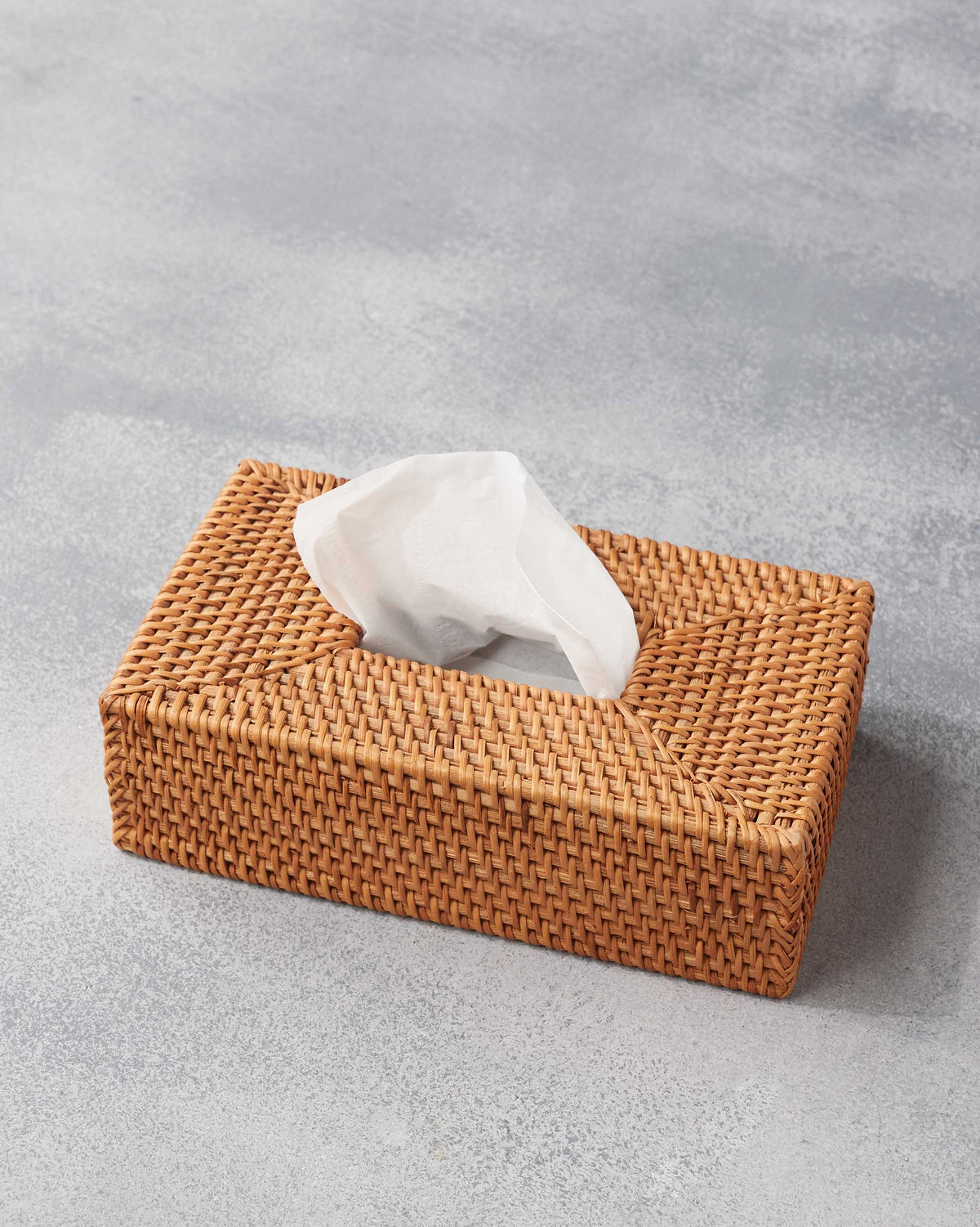 Rattan tissue cover with a white tissue pulled from the top opening.