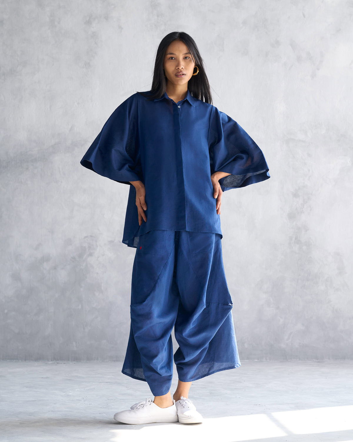 Person wearing navy Yoka Trousers with a matching shirt.