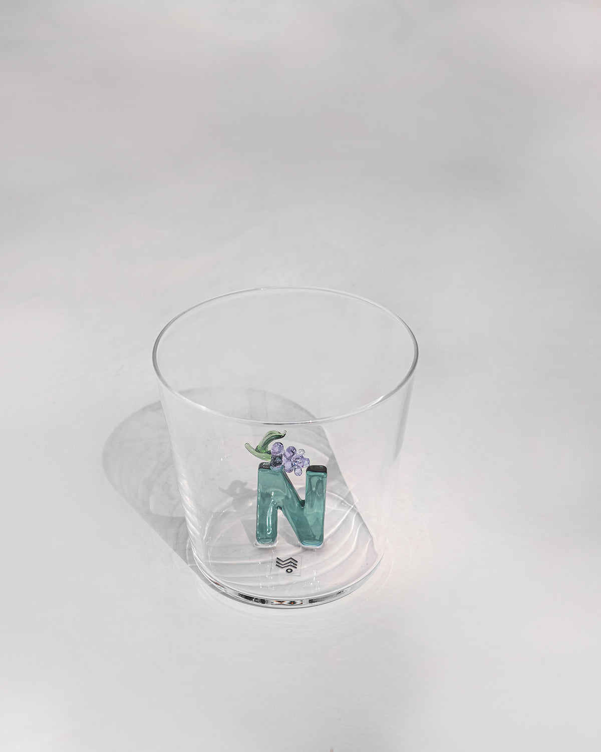 Clear Alphabet glass showing a teal letter N with purple flowers at the base.