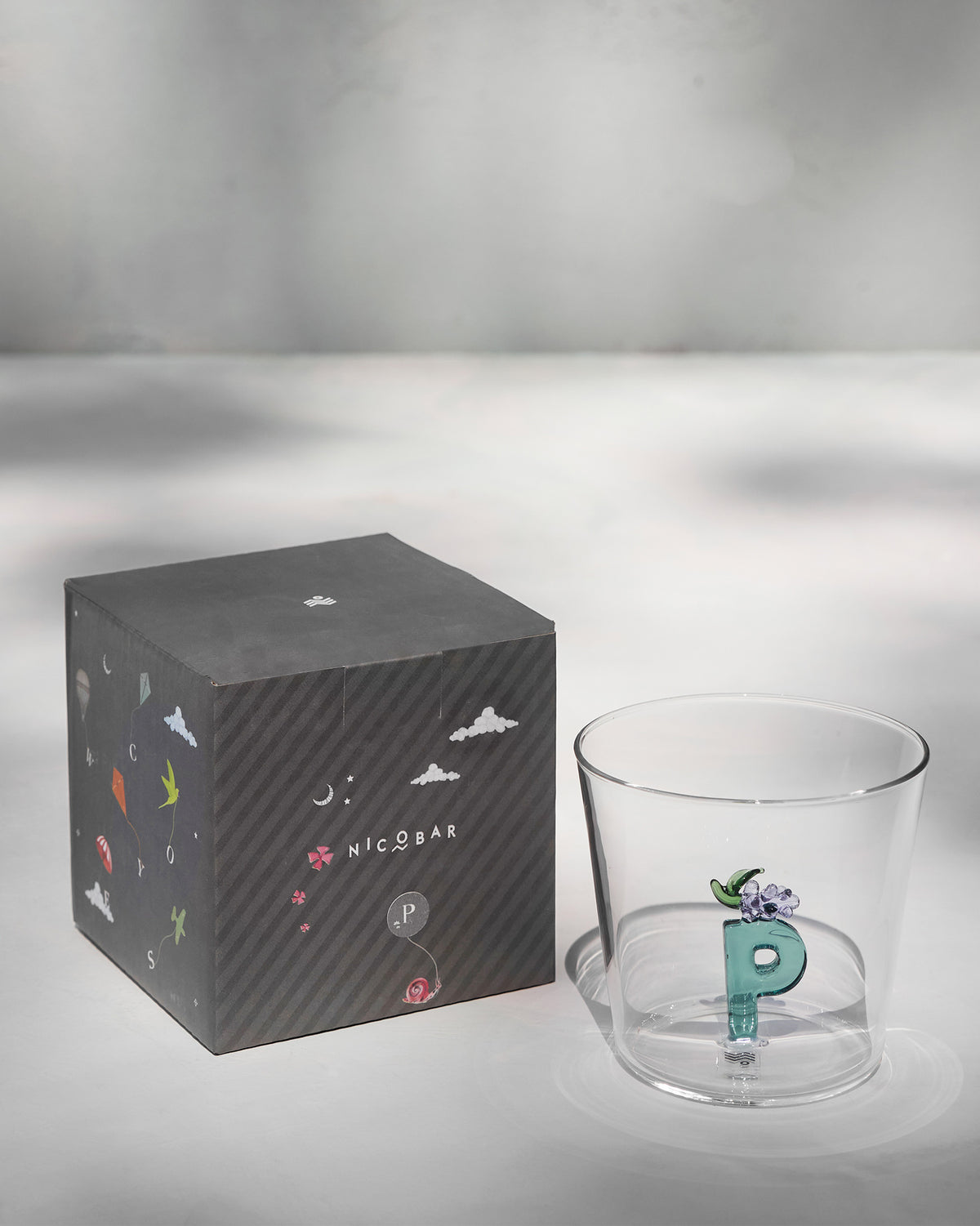 Alphabet Glass P with teal letter P beside its kite-print gift box.