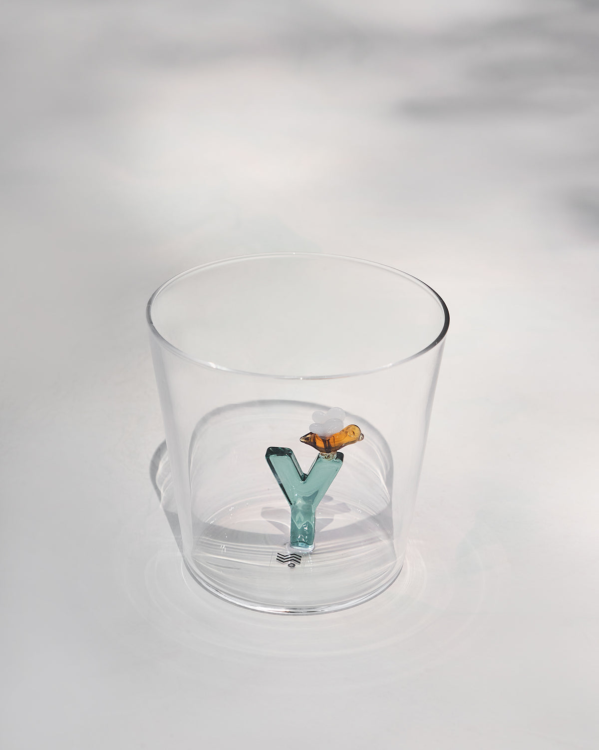 Clear Alphabet glass showing a teal letter Y with an amber bee at the base.