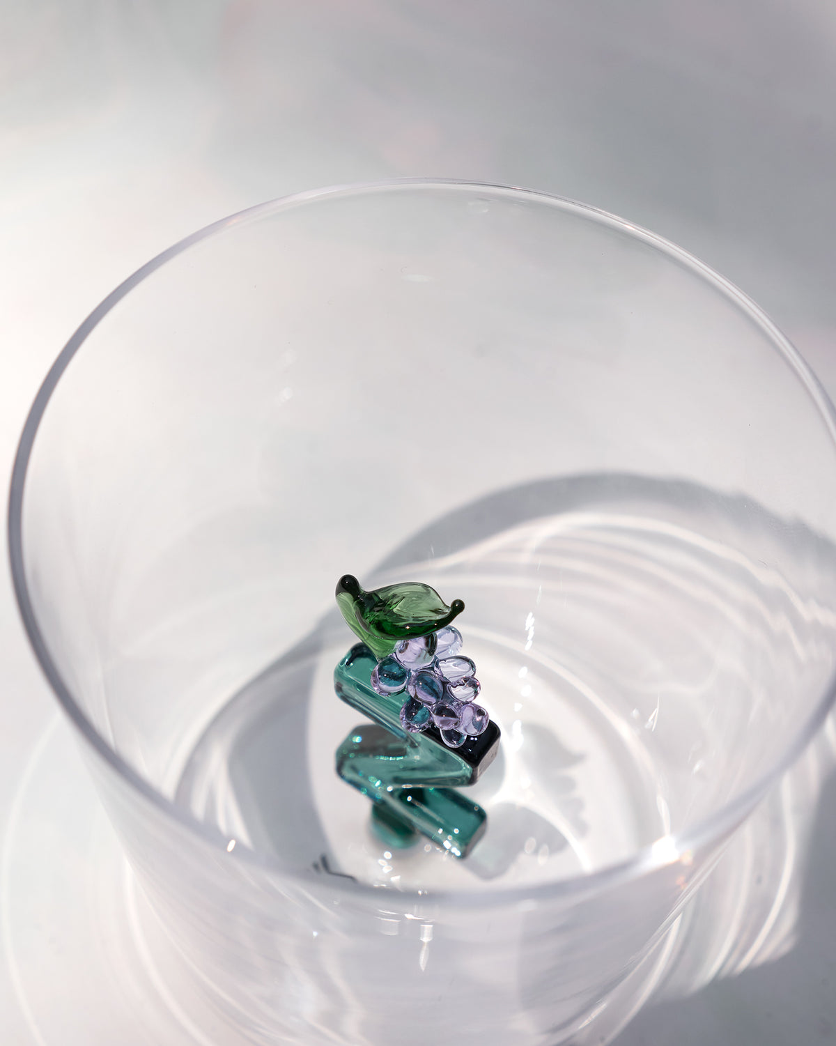 Overhead view of an Alphabet glass with a teal letter Z and purple grapes.