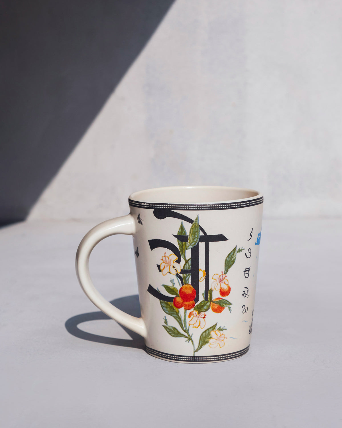 Cream Owl mug with script character and orange fruit blossom print.