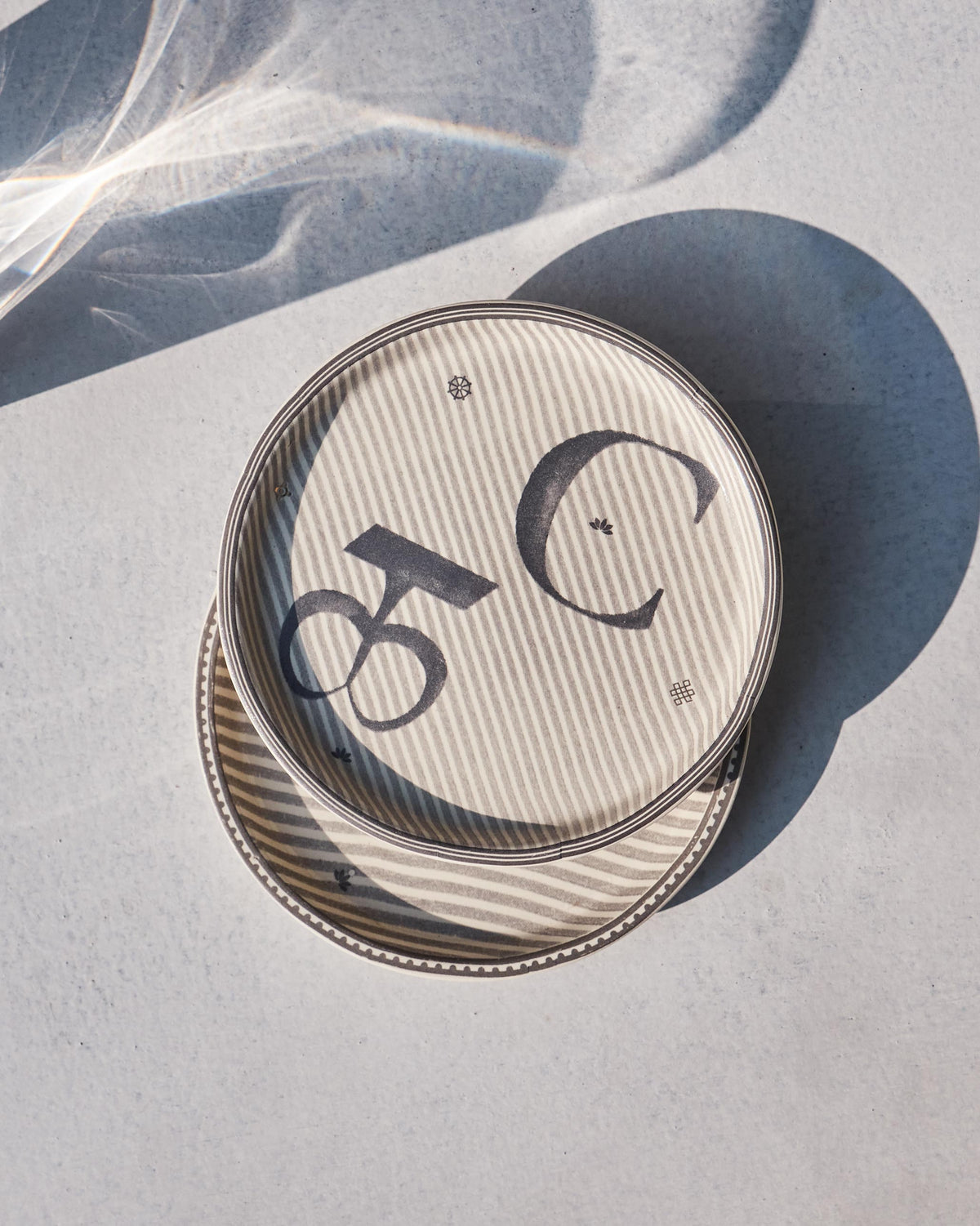 Akshar Coaster - C stacked over a second coaster, showing the grey C glyph.