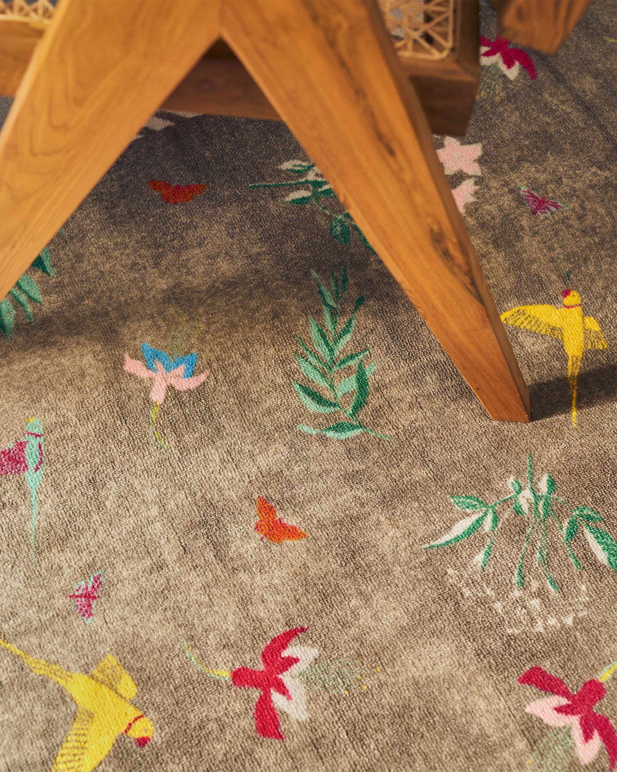 Close-up of the Liba Rug showing its yellow birds and red and pink flowers.