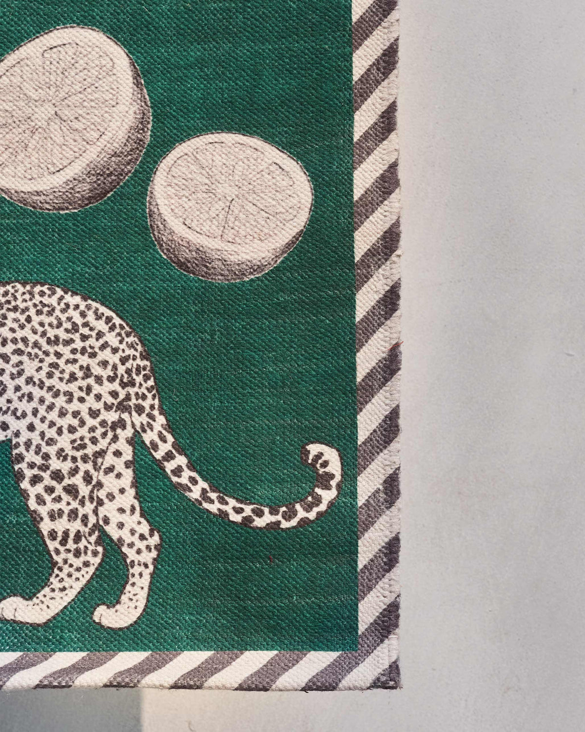 Close-up of Zaka Rug corner with a leopard and striped border.