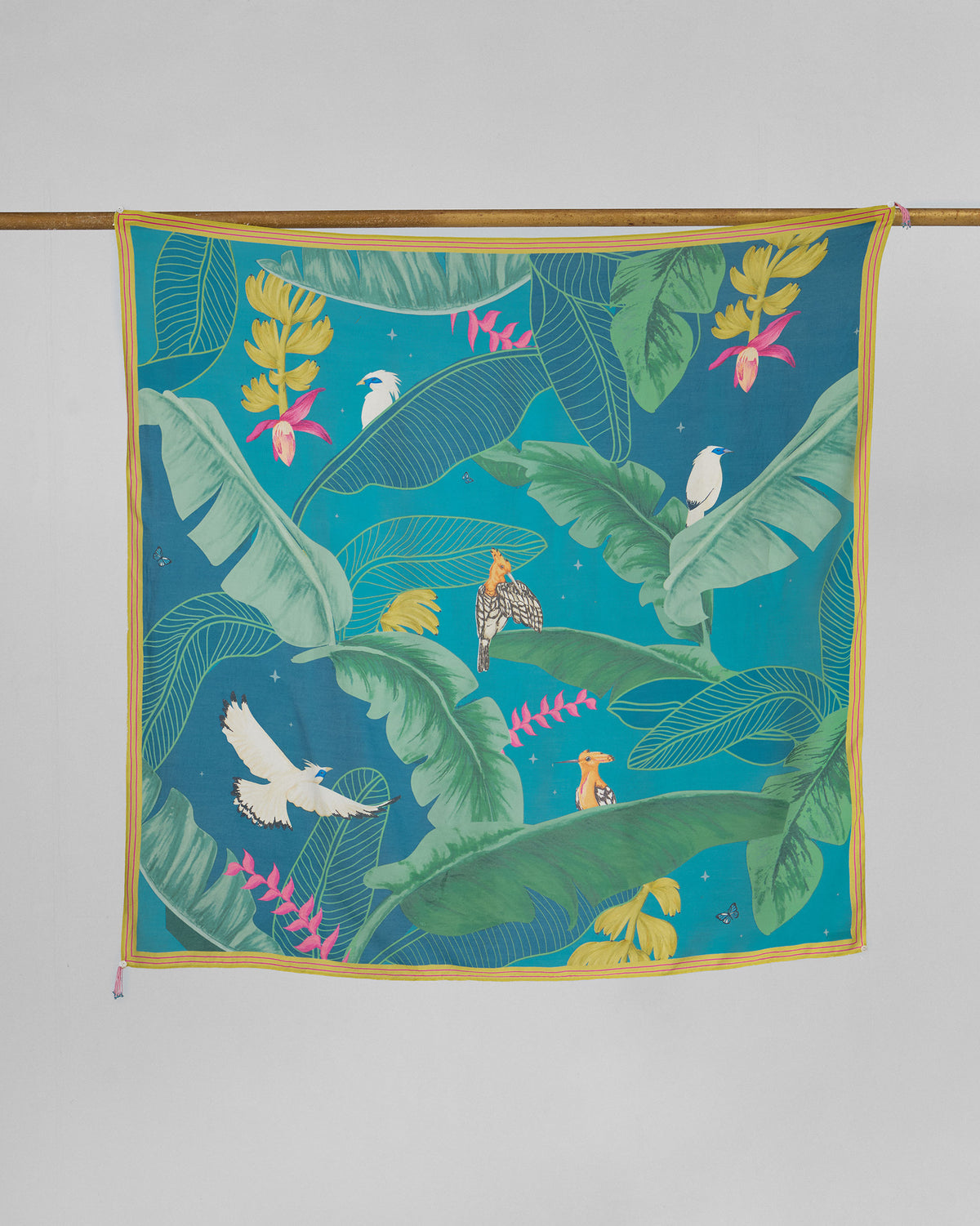 Hideaway scarf hung flat, showing green leaves and white and orange birds on teal.