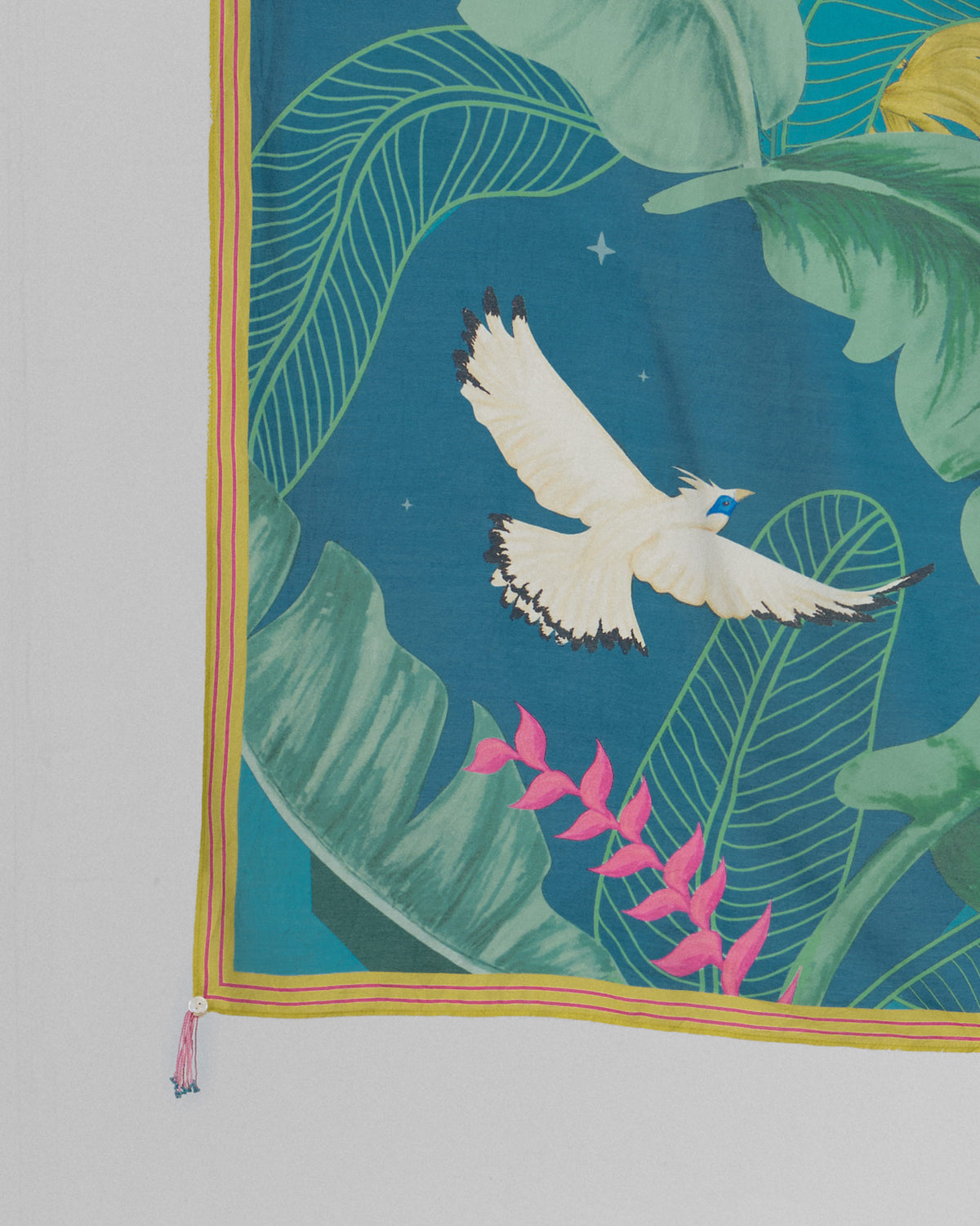 Close-up of a Hideaway scarf corner showing a white bird in flight and pink flowers.