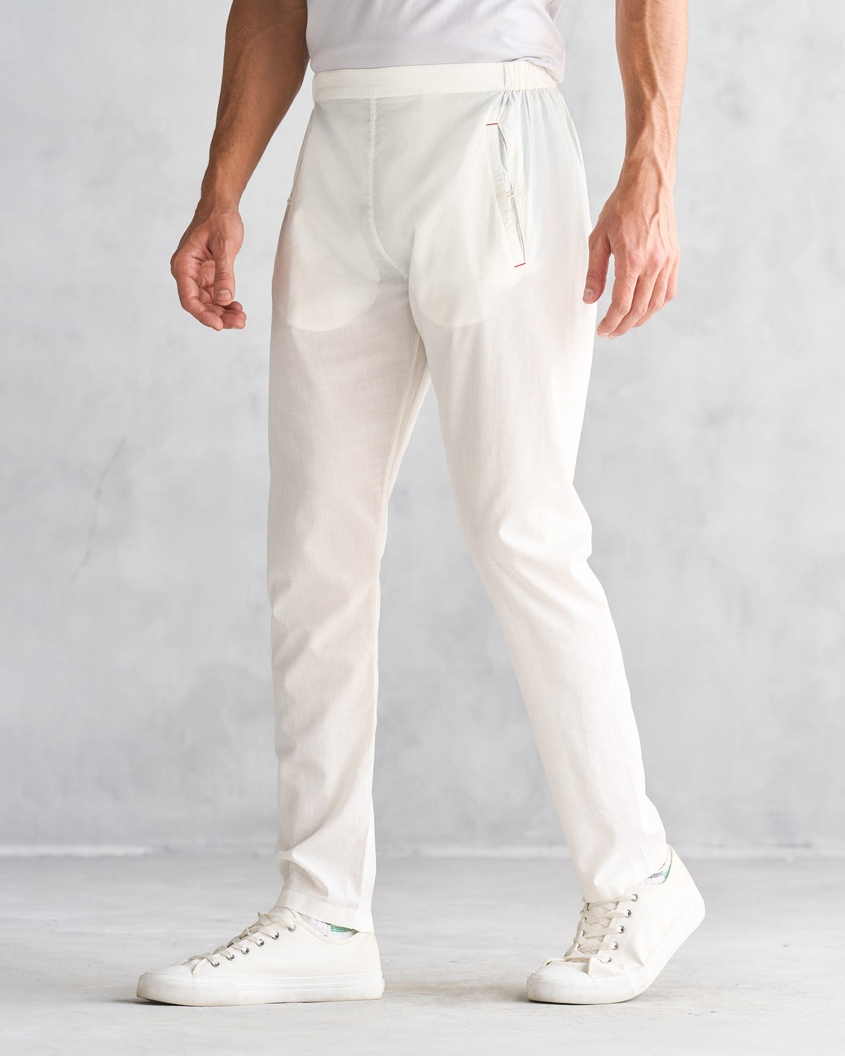 Side view of ivory Kurta Pants worn by a person, showing the zip pocket.