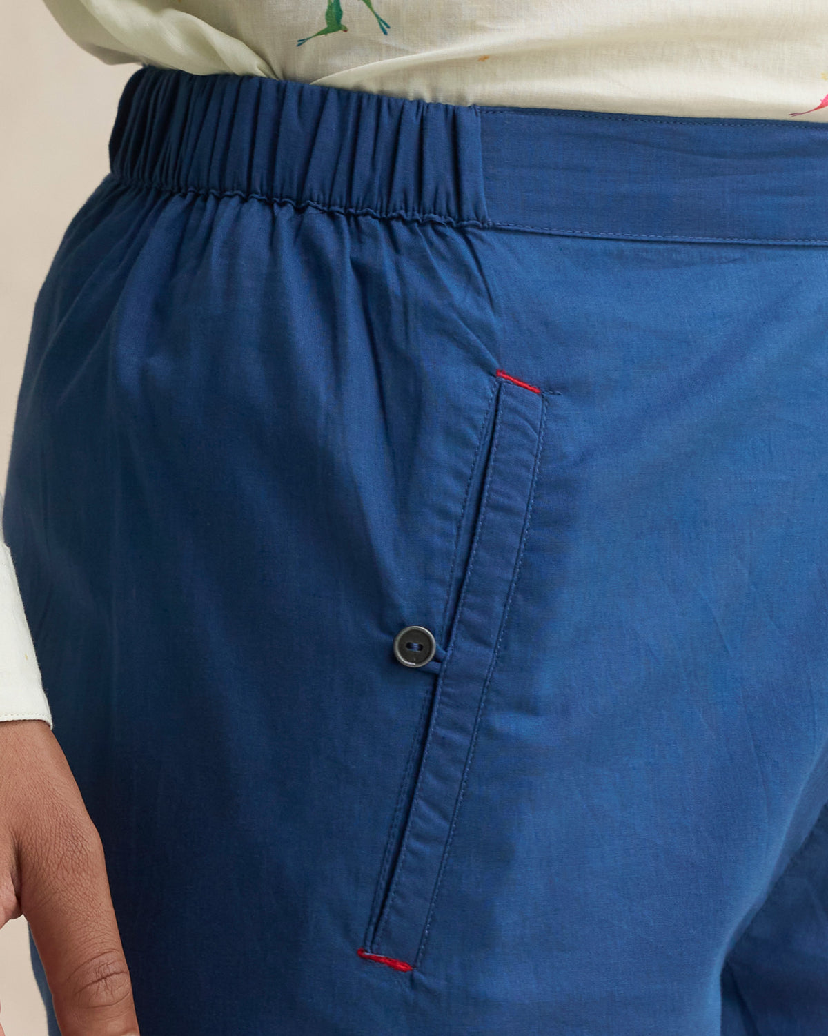 Close-up of navy Kurta Pants showing a side pocket with a button.
