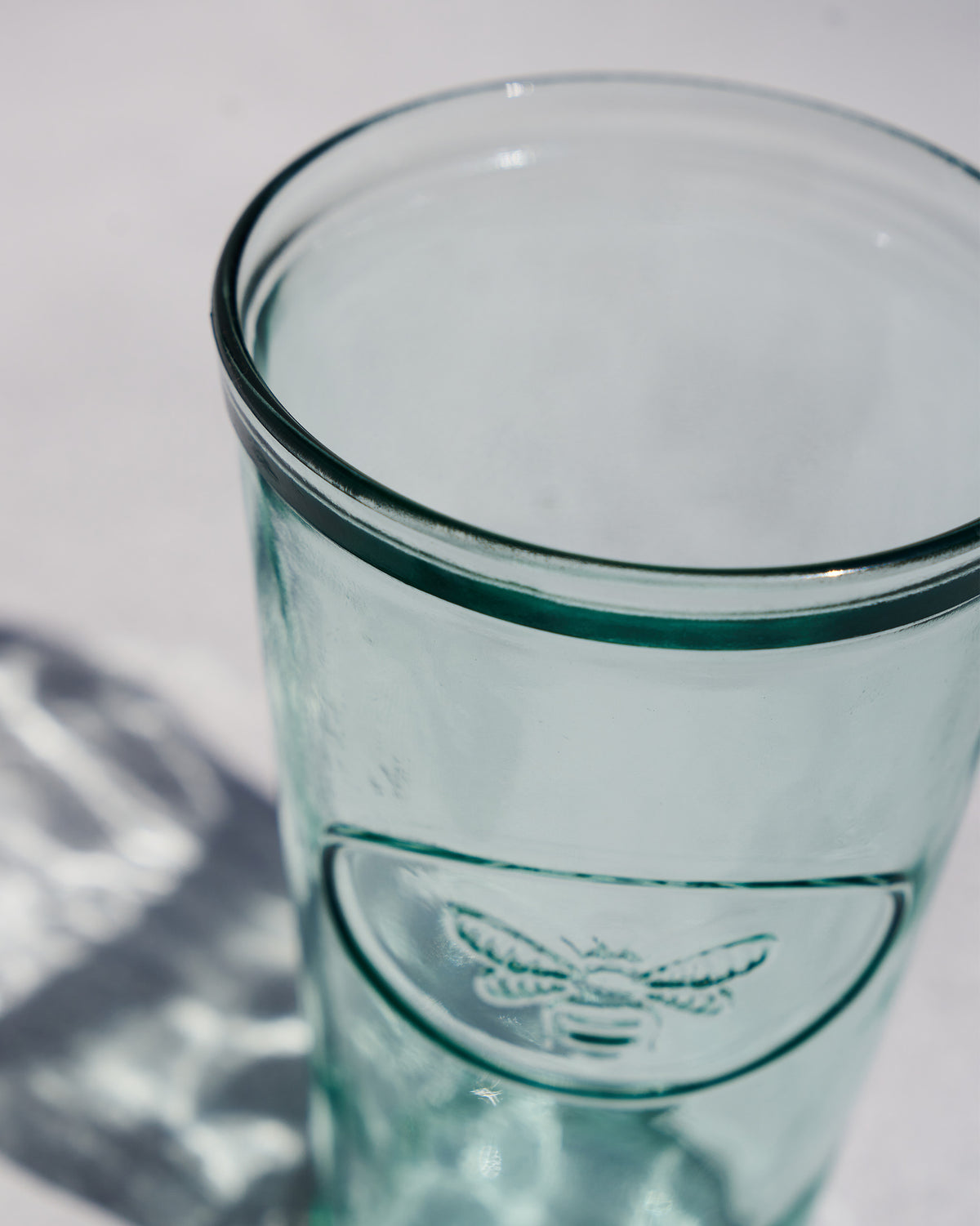 Close-up of the Firefly Beer Glass showing its rim and embossed insect.