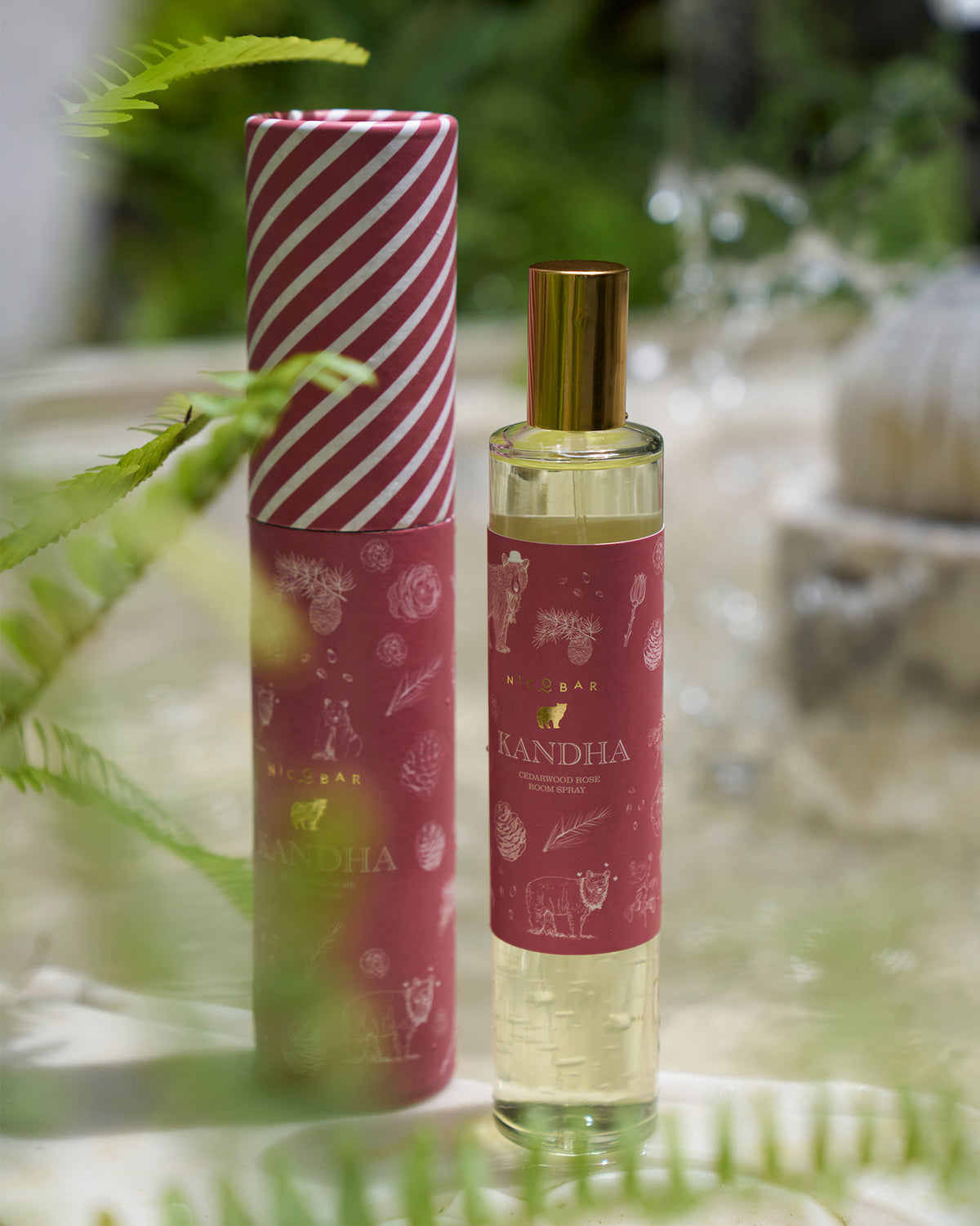 Kandha room spray bottle and striped tube packaging outdoors.