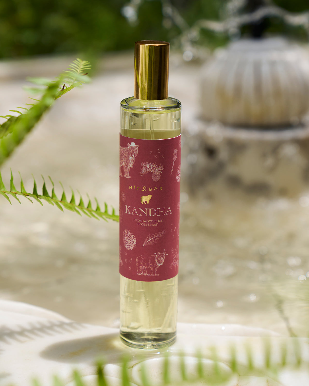 Clear Kandha room spray bottle with maroon label and gold cap.