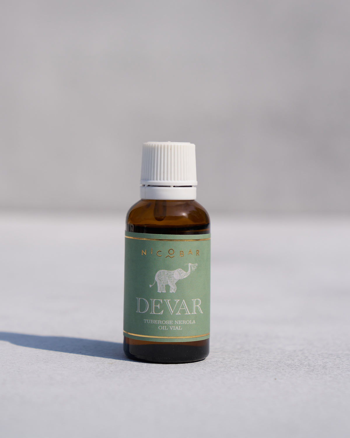 Devar oil vial with an amber glass bottle and white cap.