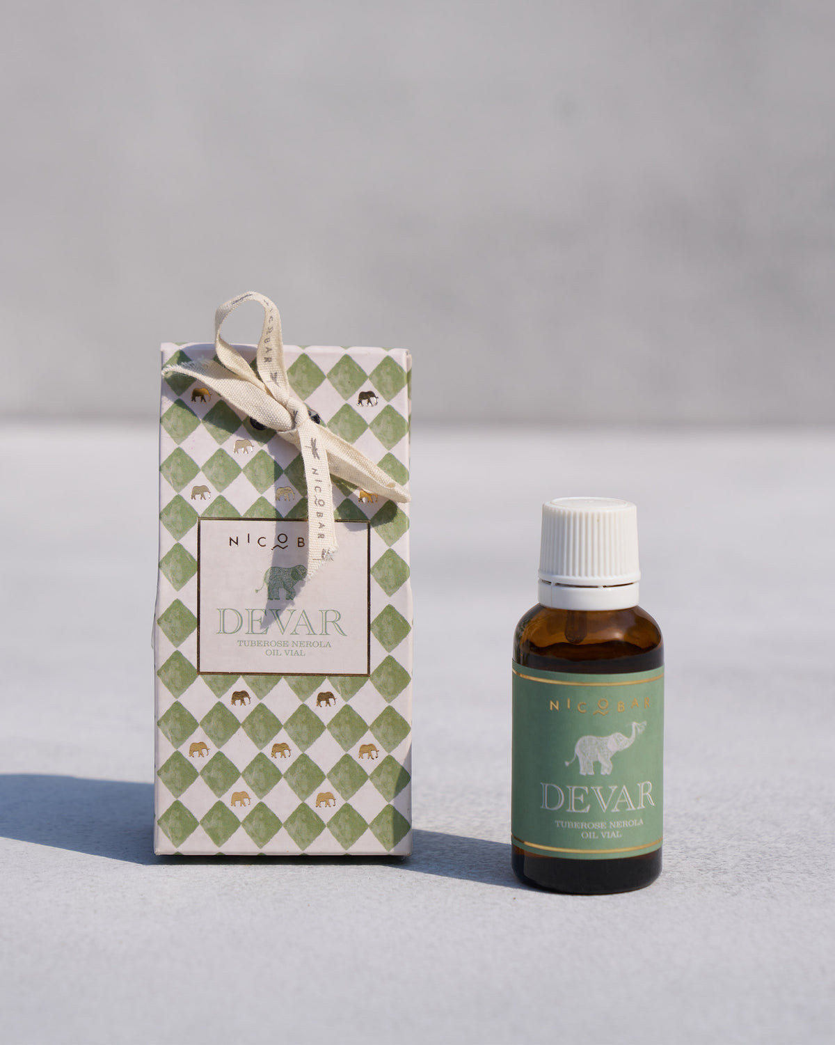 Devar oil vial beside its patterned gift box.