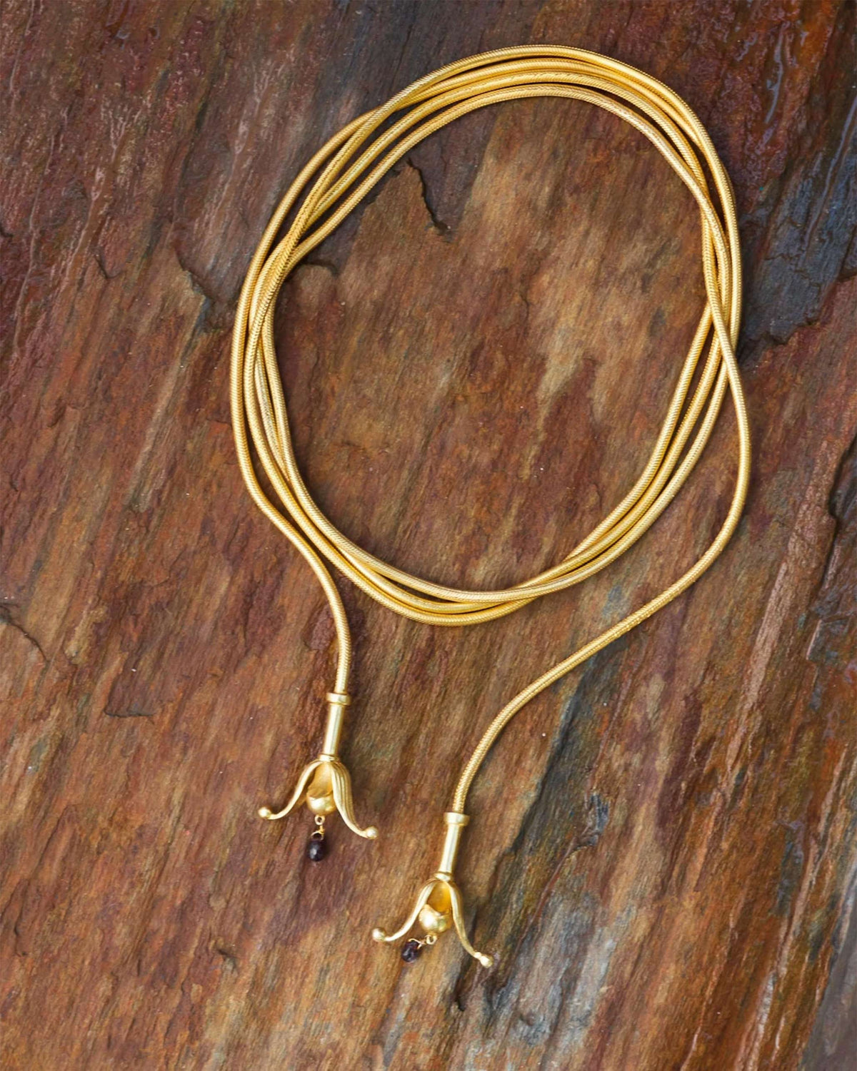 Gold Phool Chain looped out, showing flower-shaped ends and small red drops.