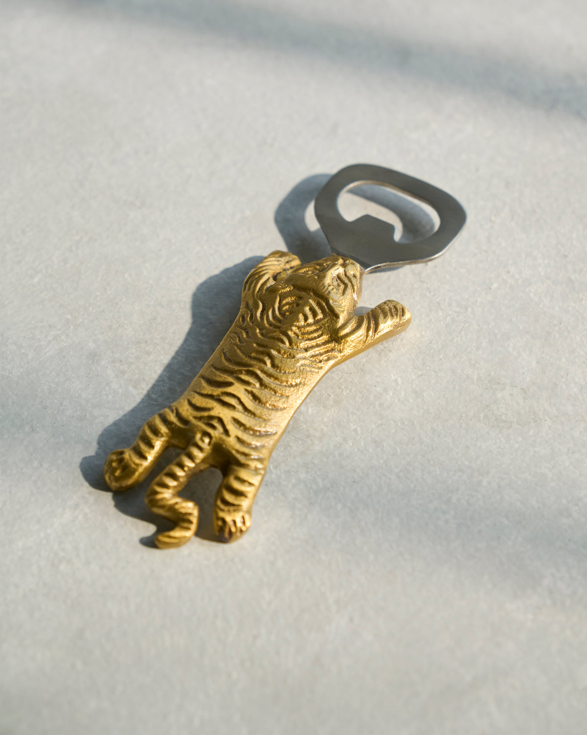 Gold Sumatran tiger bottle opener showing striped brass detail.