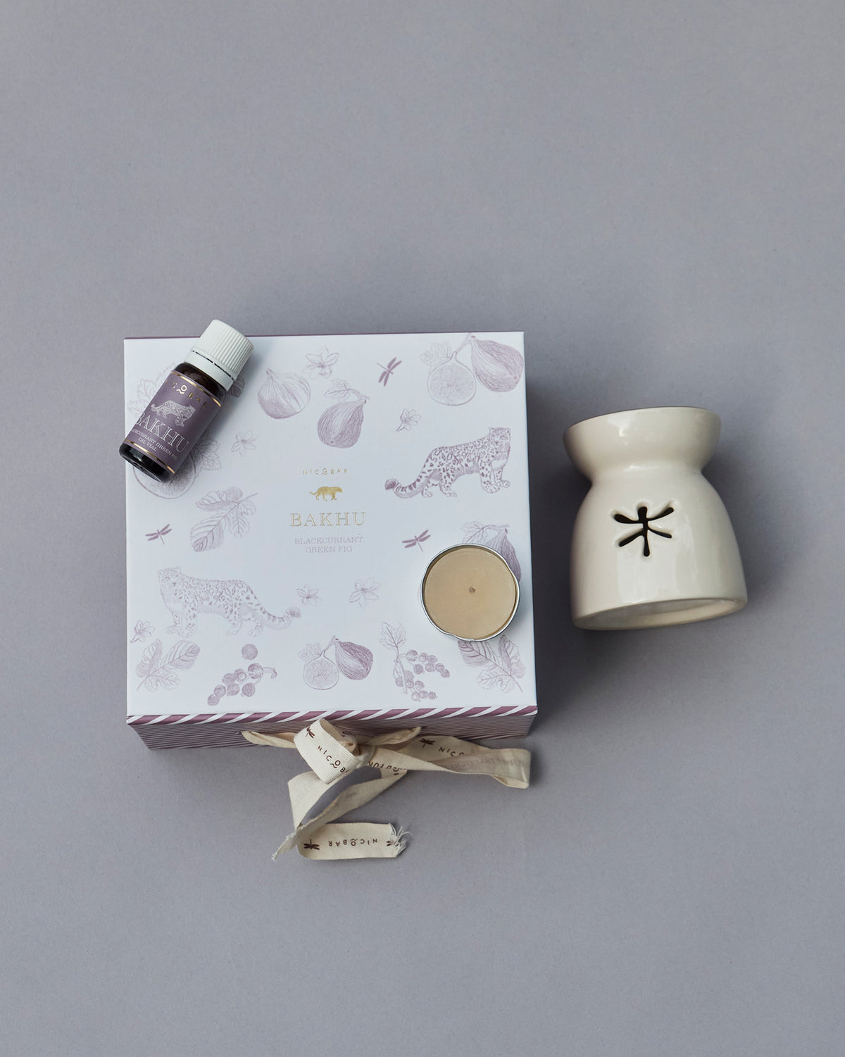 Sattva gift box and cream oil burner seen from above, with a bottle on the lid.